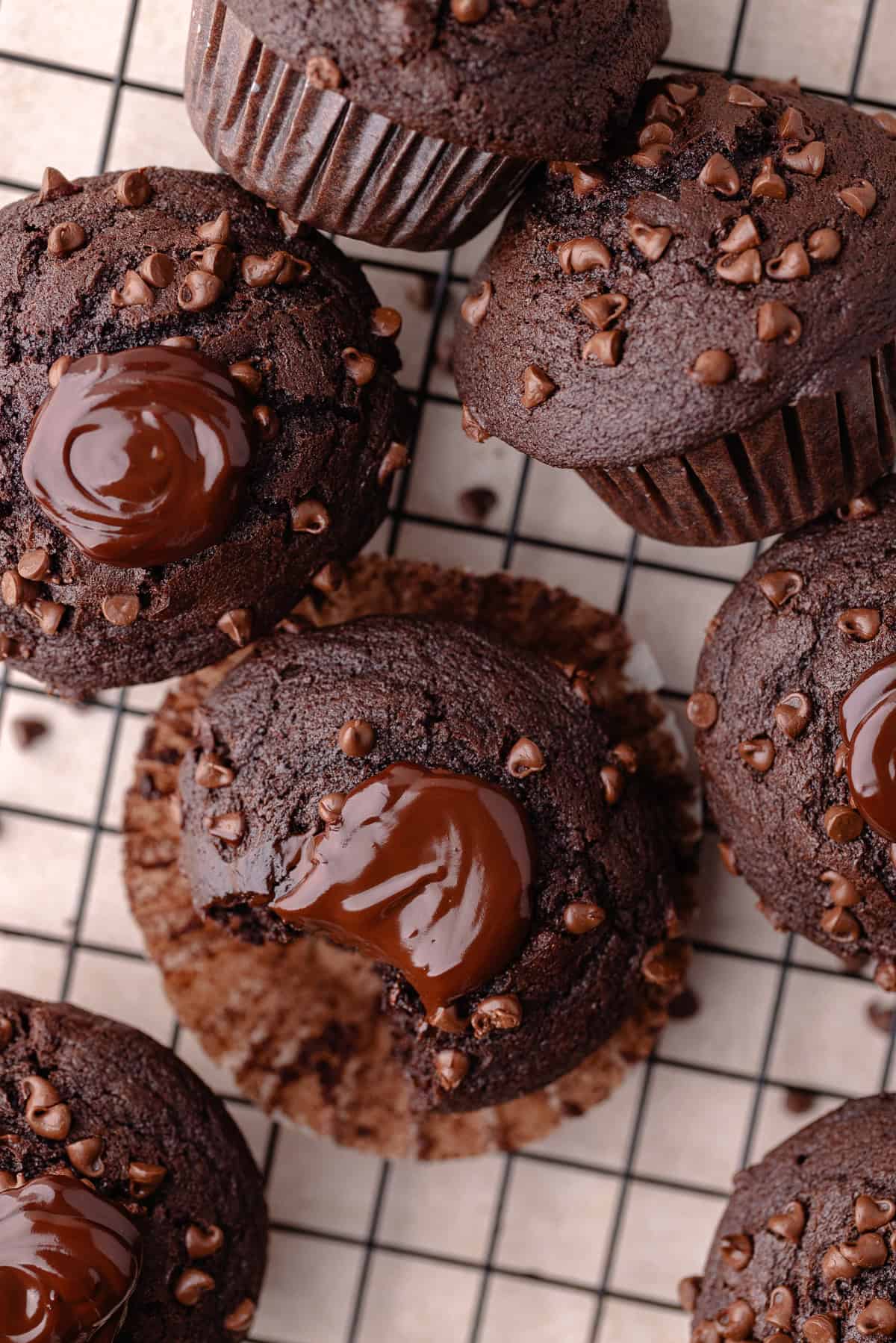 Triple chocolate muffins on a wire rack.