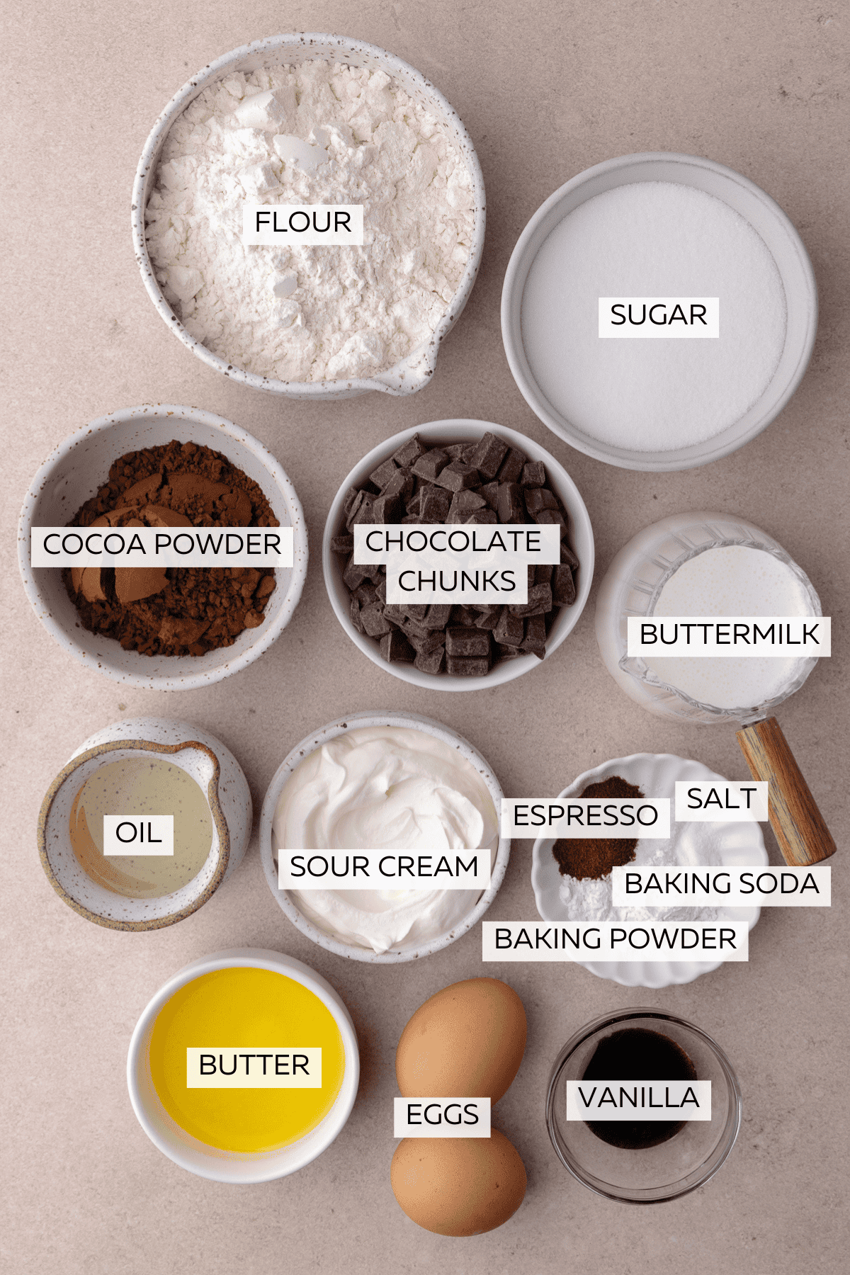 Ingredients for Chocolate Muffins which include, flour, cocoa powder, baking soda, baking powder, salt, espresso powder, eggs, sugars, butter, oil, buttermilk, sour cream, vanilla and chocolate chunks.