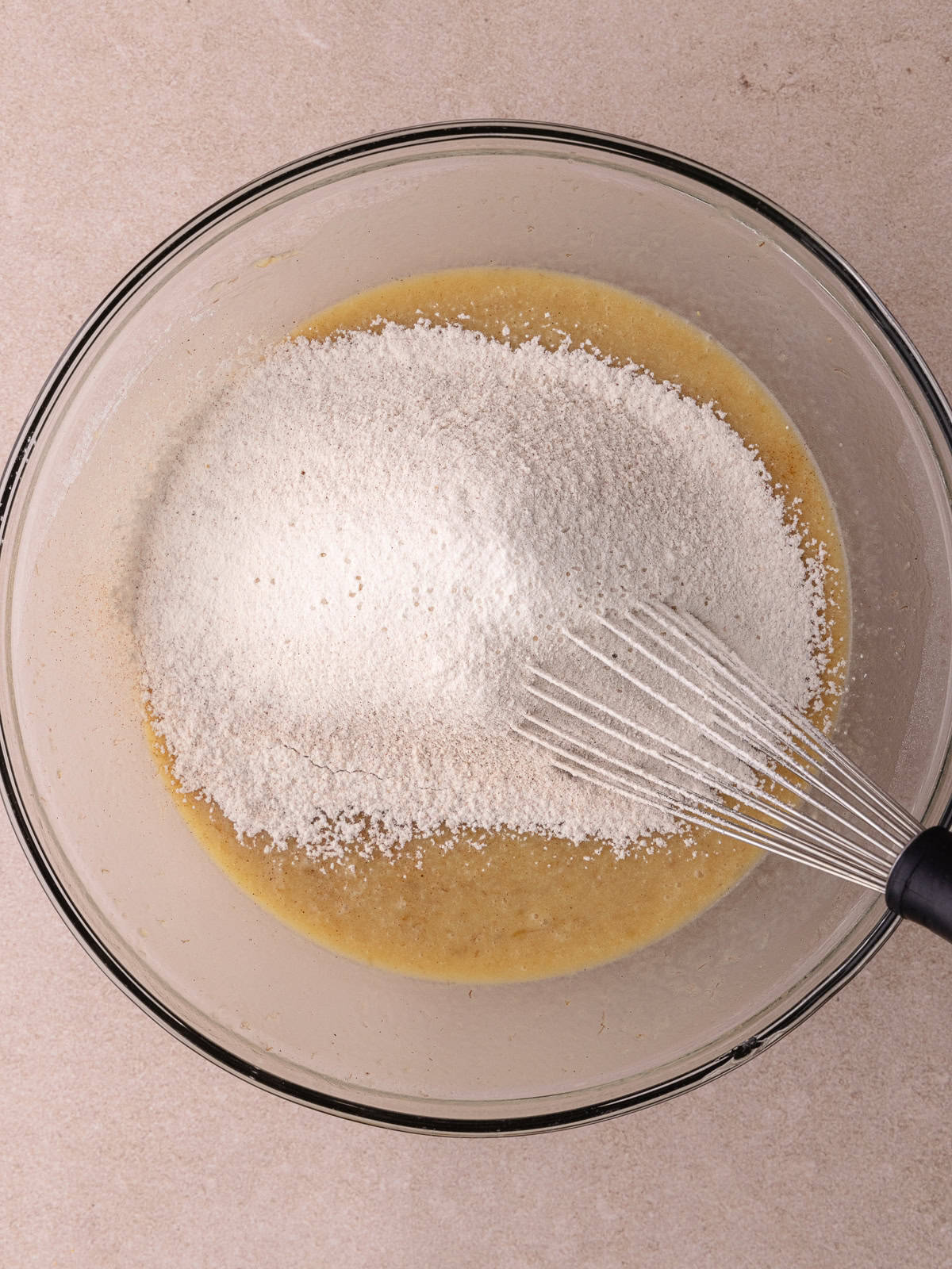 Dry ingredients are sifted into the wet ingredients.