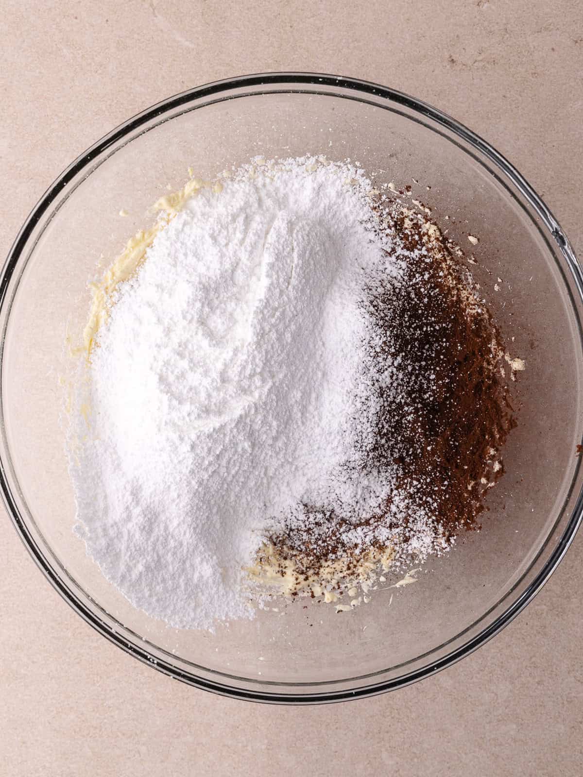 Powdered sugar and cocoa powder is added to cream cheese/butter mixture.