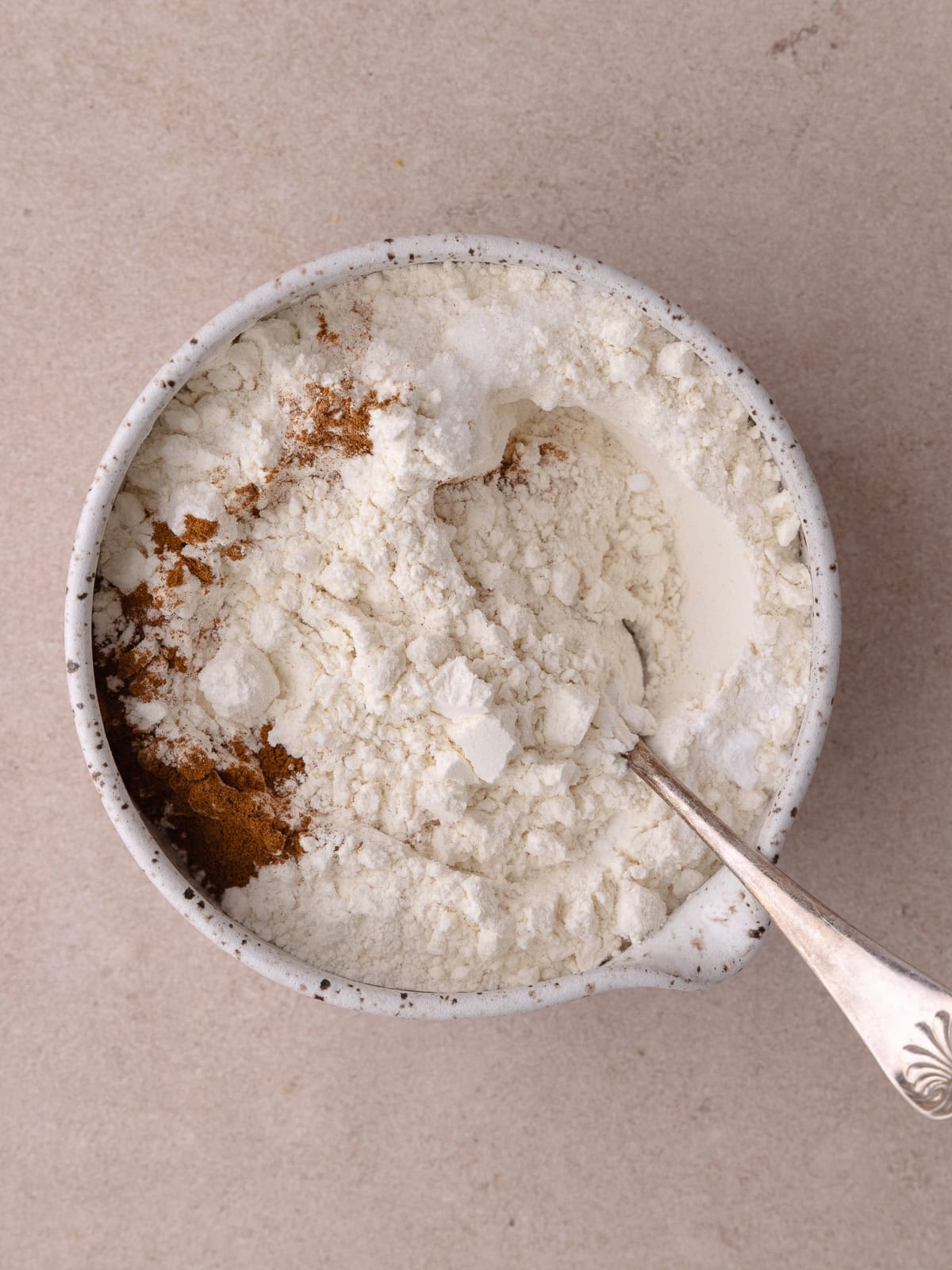 Flour, baking soda, baking powder, cinnamon and salt are combined in a small bowl.