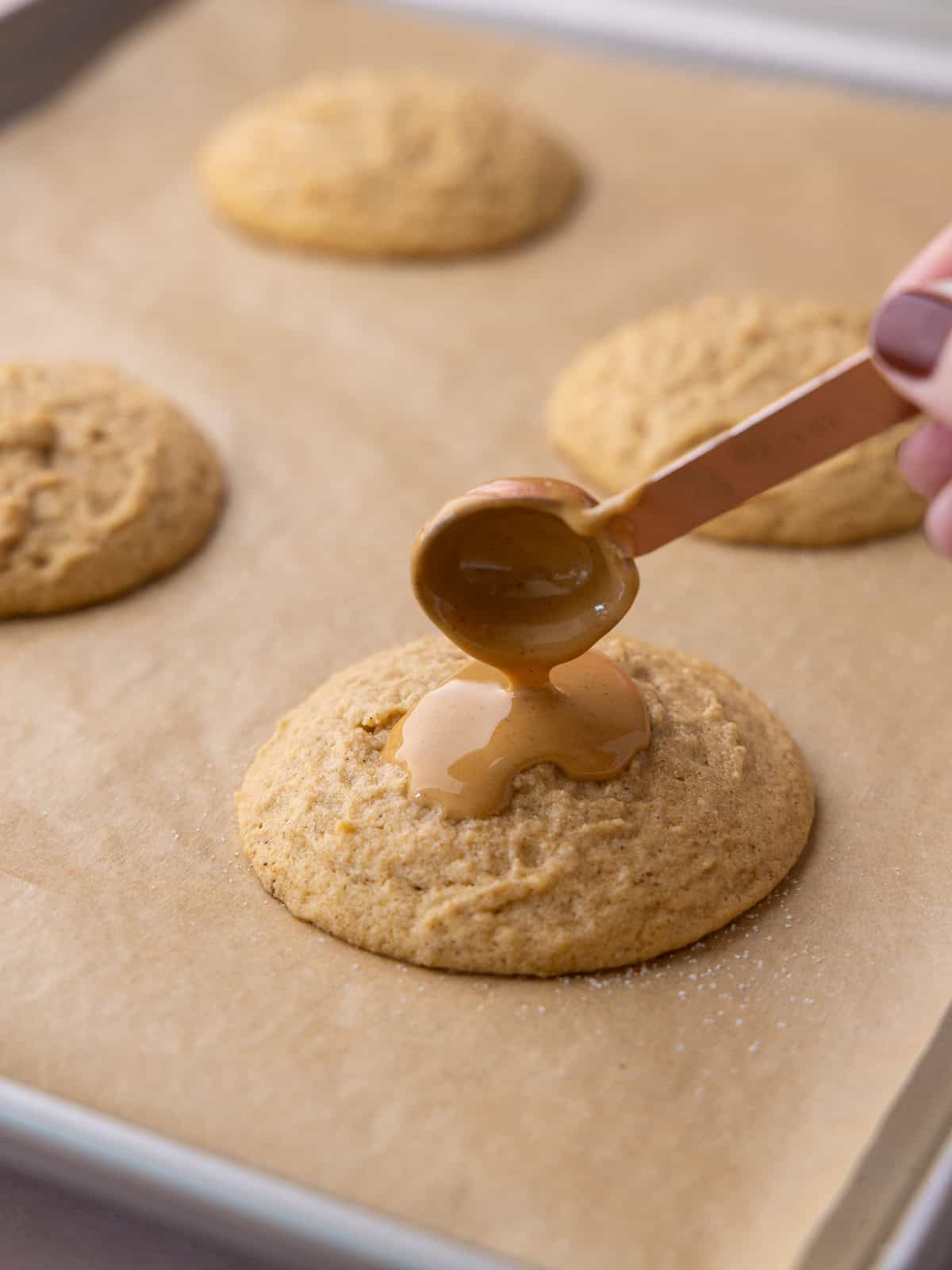 Melted peanut butter is added on top of par bake cookies.