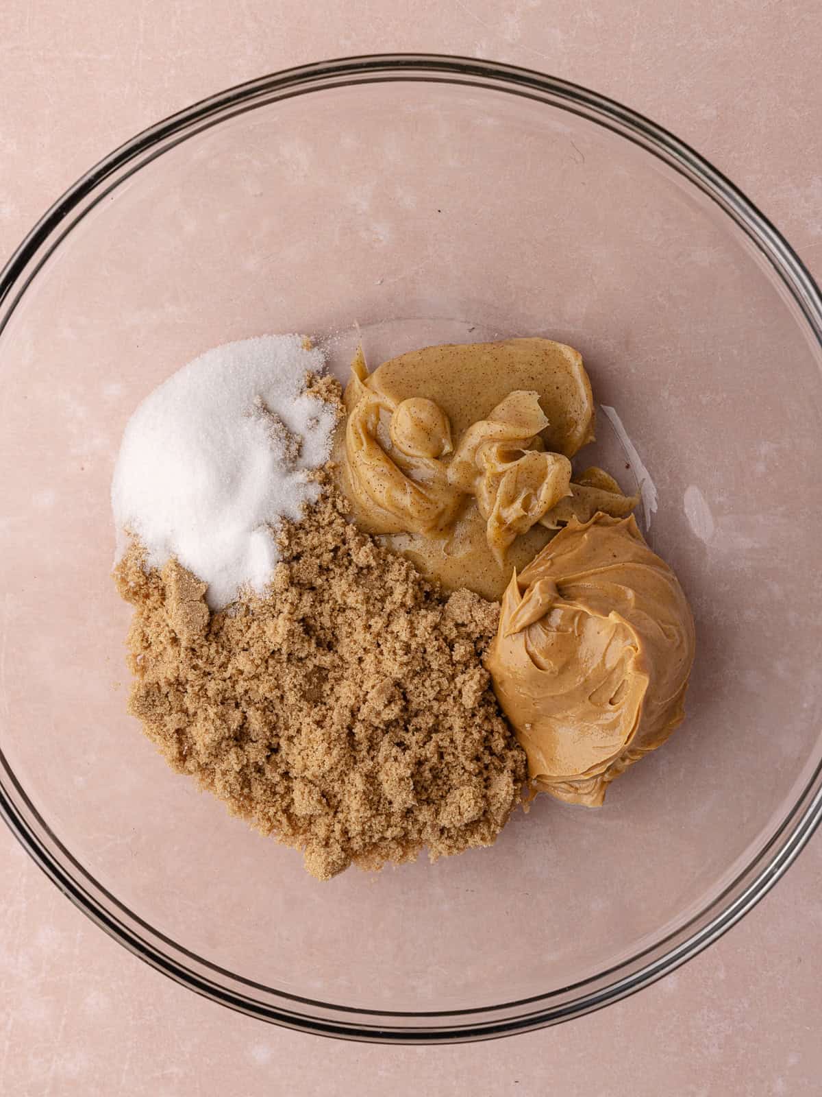 Brown butter, peanut butter, brown sugar and white sugar are in a large mixing bowl.