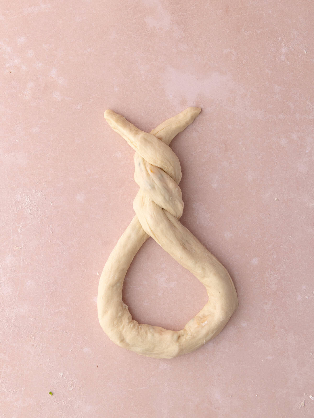 The dough is shaped into a pretzel.