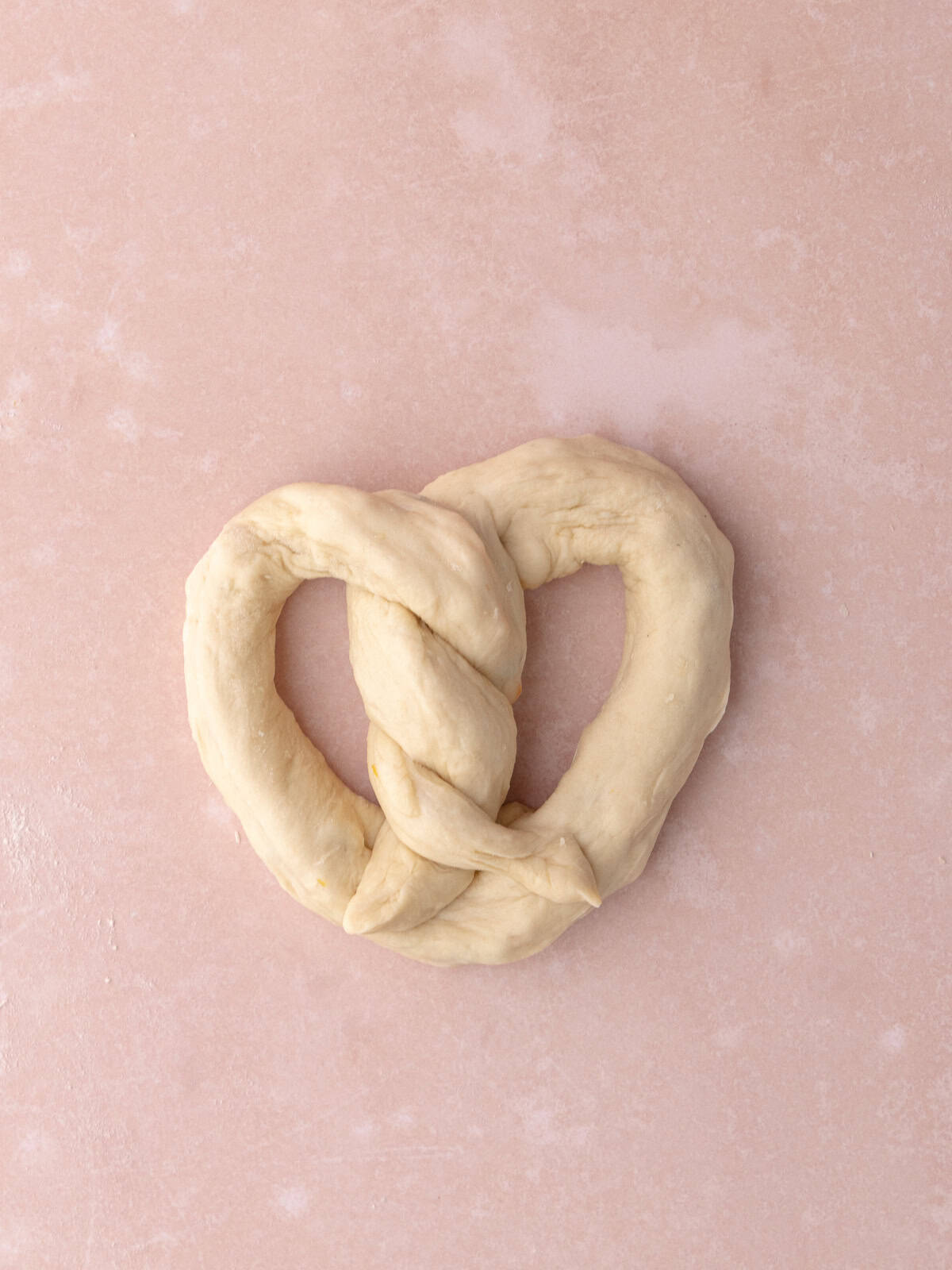 The dough is shaped into a pretzel.