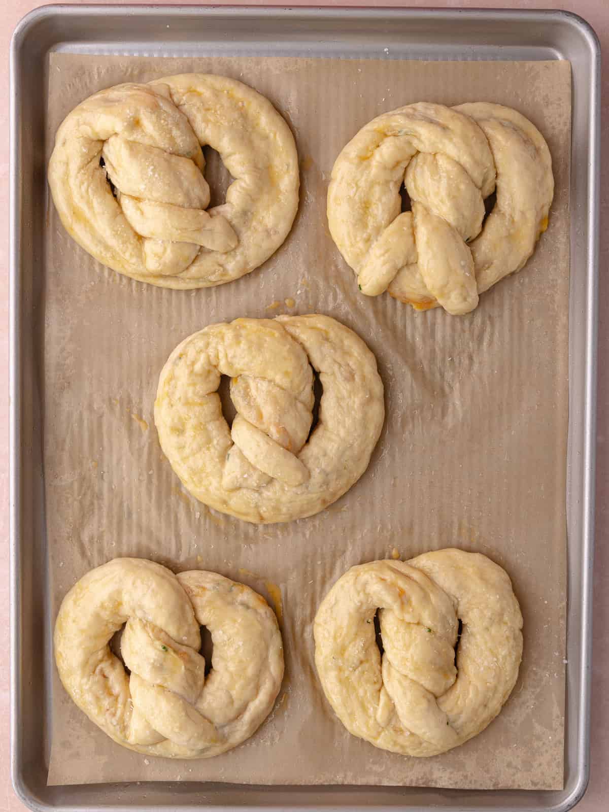 Shaped pretzels after a soda bath gets brushed with egg wash and salt.