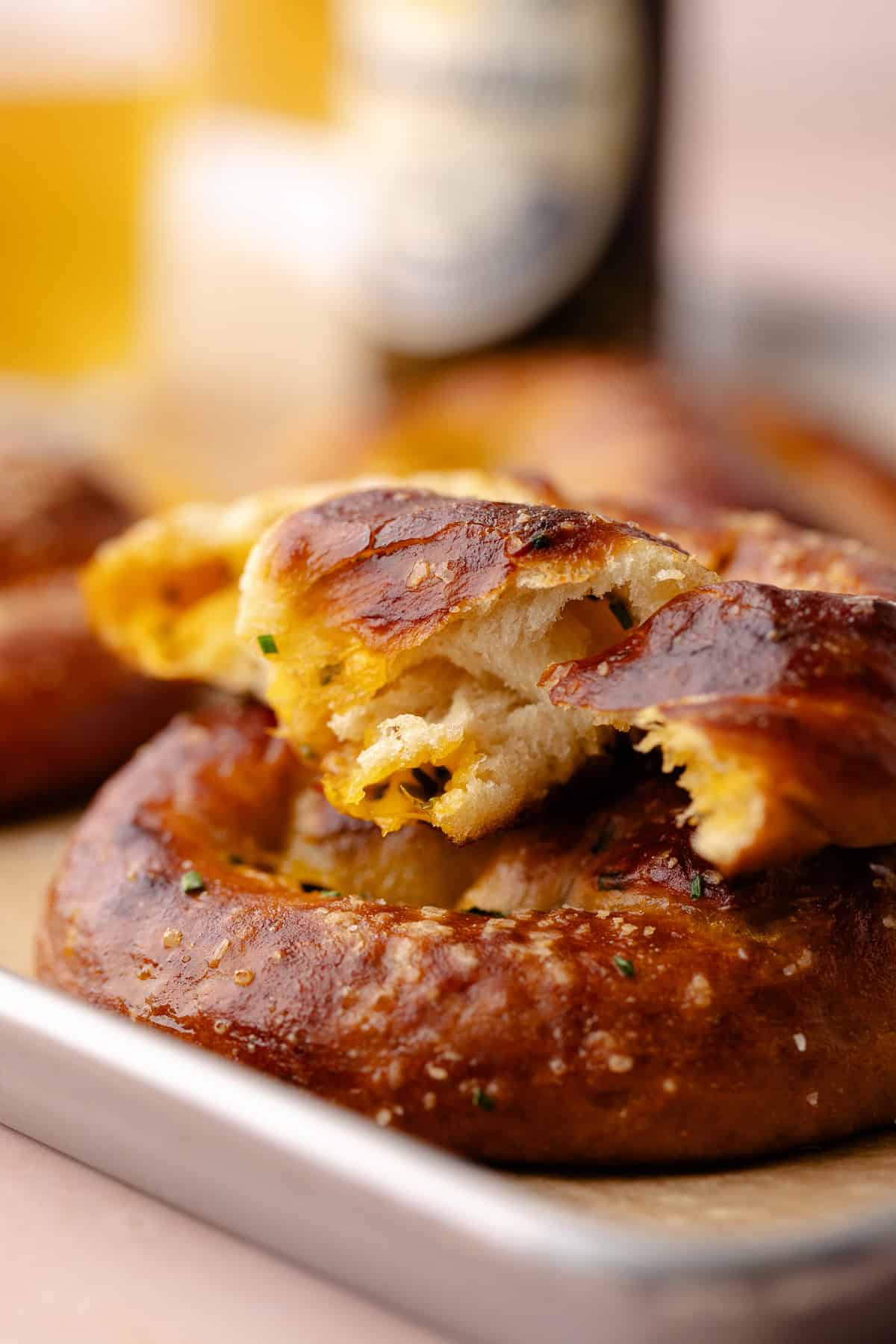 Inside of Cheddar Chive Pretzel on a cookie sheet with beer in the back.