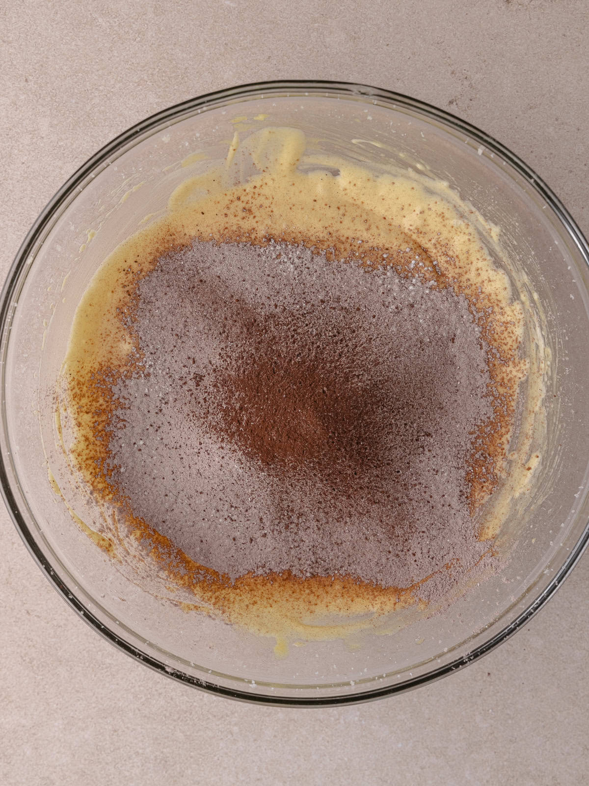 The dry ingredients are sifted into the bowl with the wet ingredients.