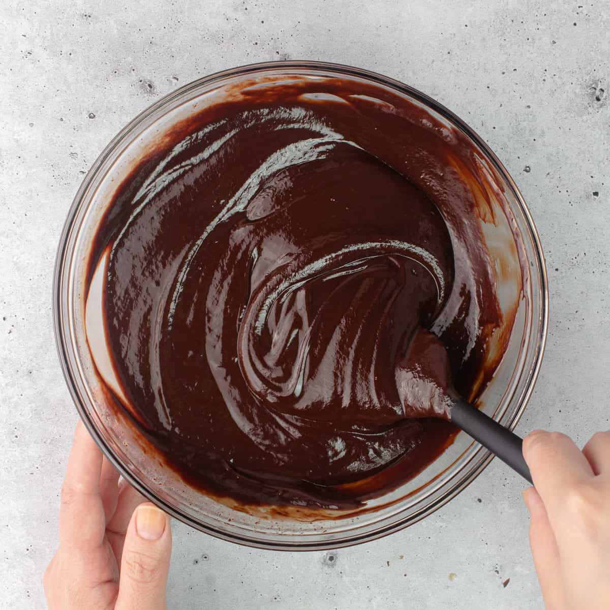 Earl grey chocolate ganache is stirred together with a rubber spatula.