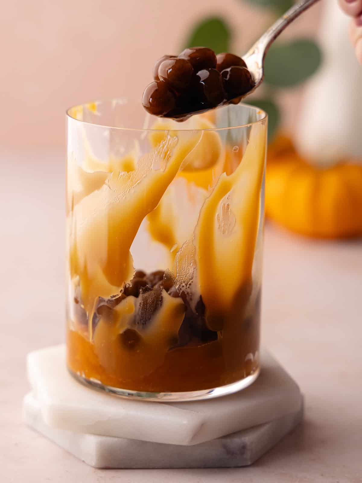 Boba pearls are added to glass.