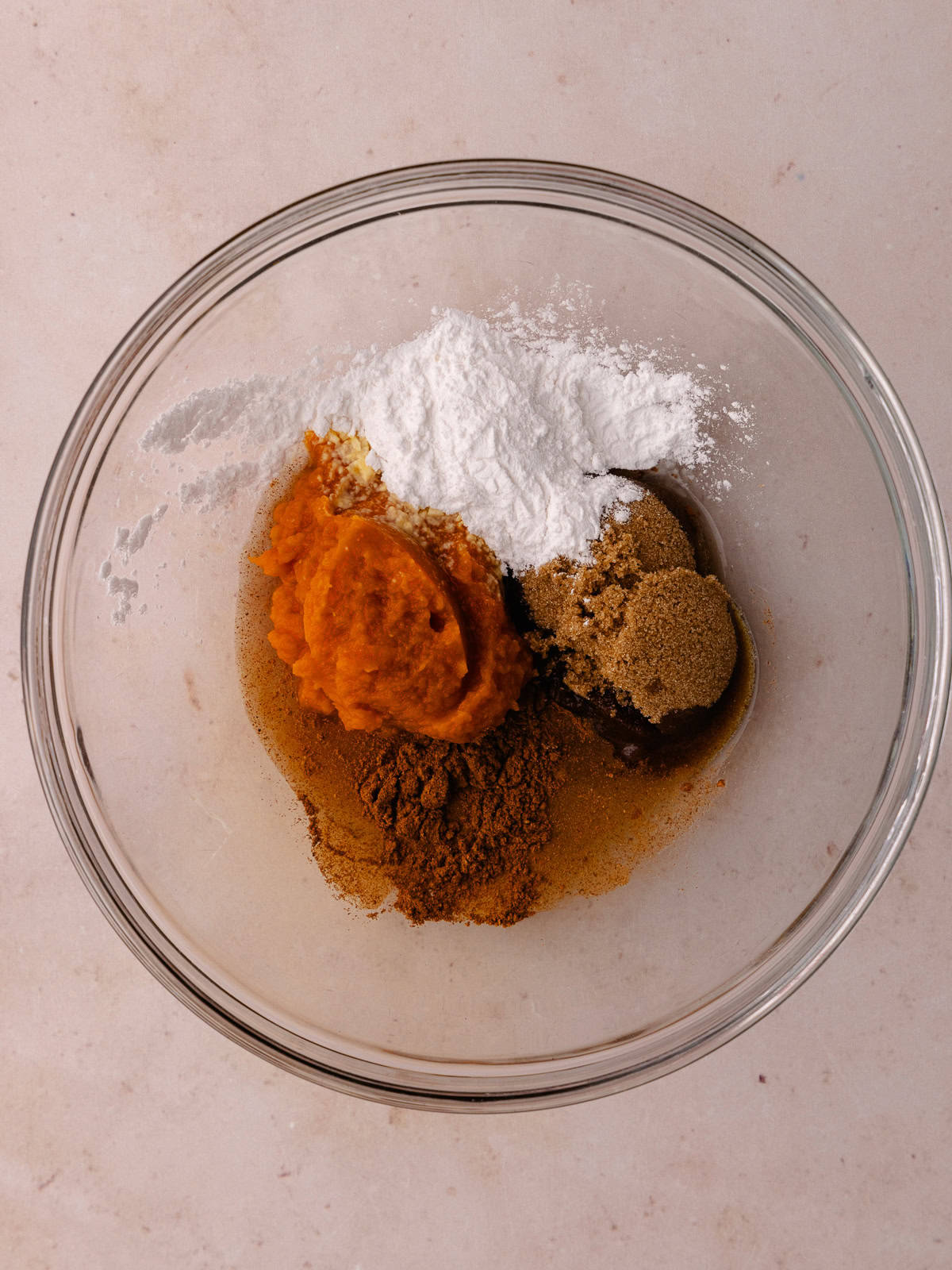 Pumpkin puree, tapioca, brown sugar, pumpkin pie spice, and water are in a small bowl.