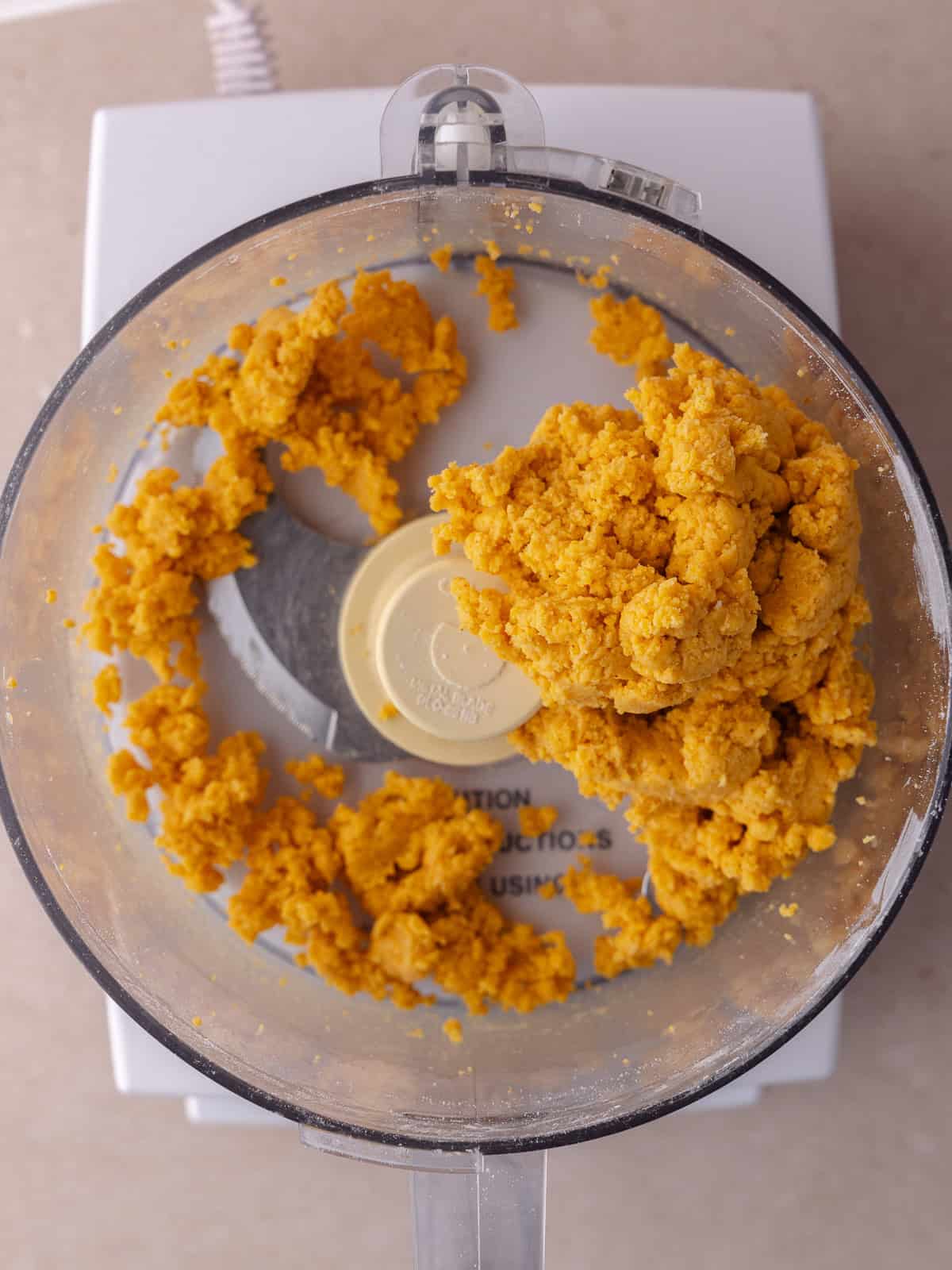 Pumpkin puree, all purpose flour, cornstarch, cheddar cheese, butter and paprika mixture is pulsed in the food processor until it starts to clump together.