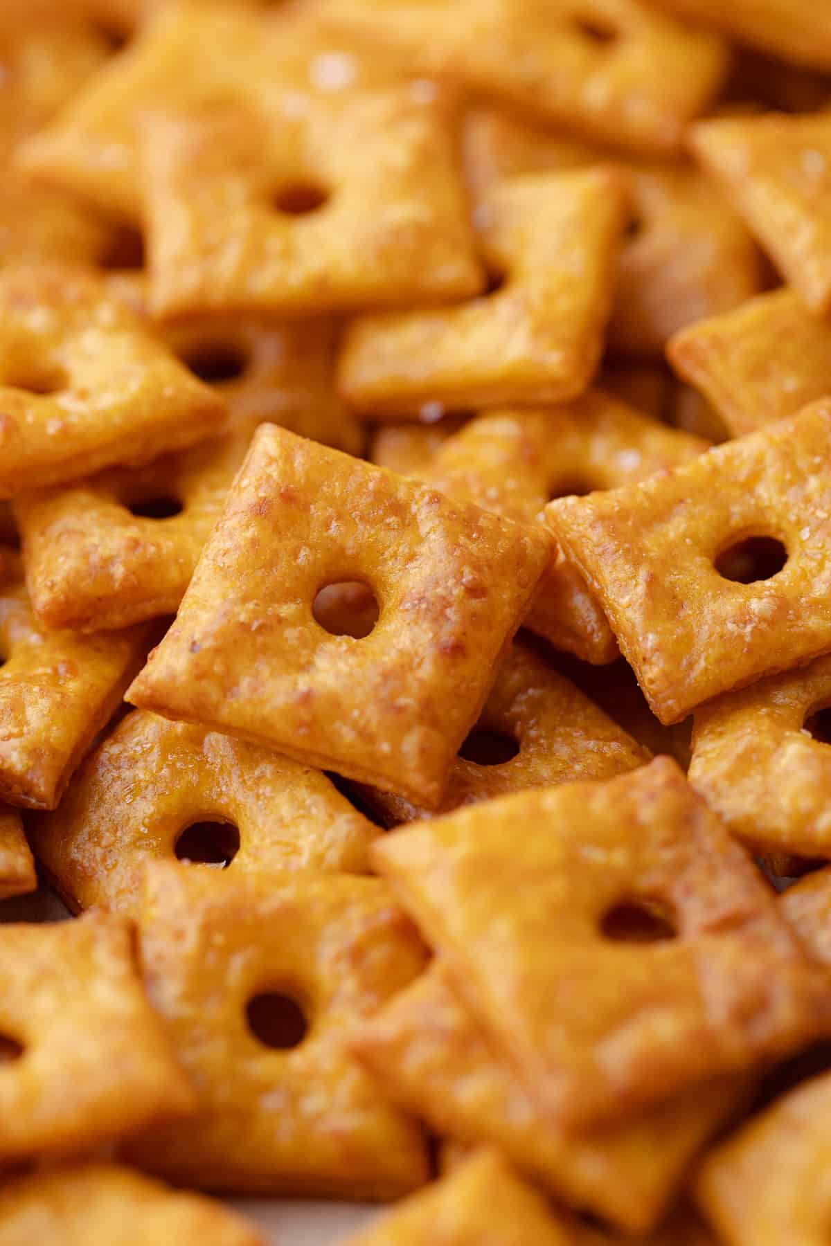 A close up of a large pile of pumpkin cheddar crackers.