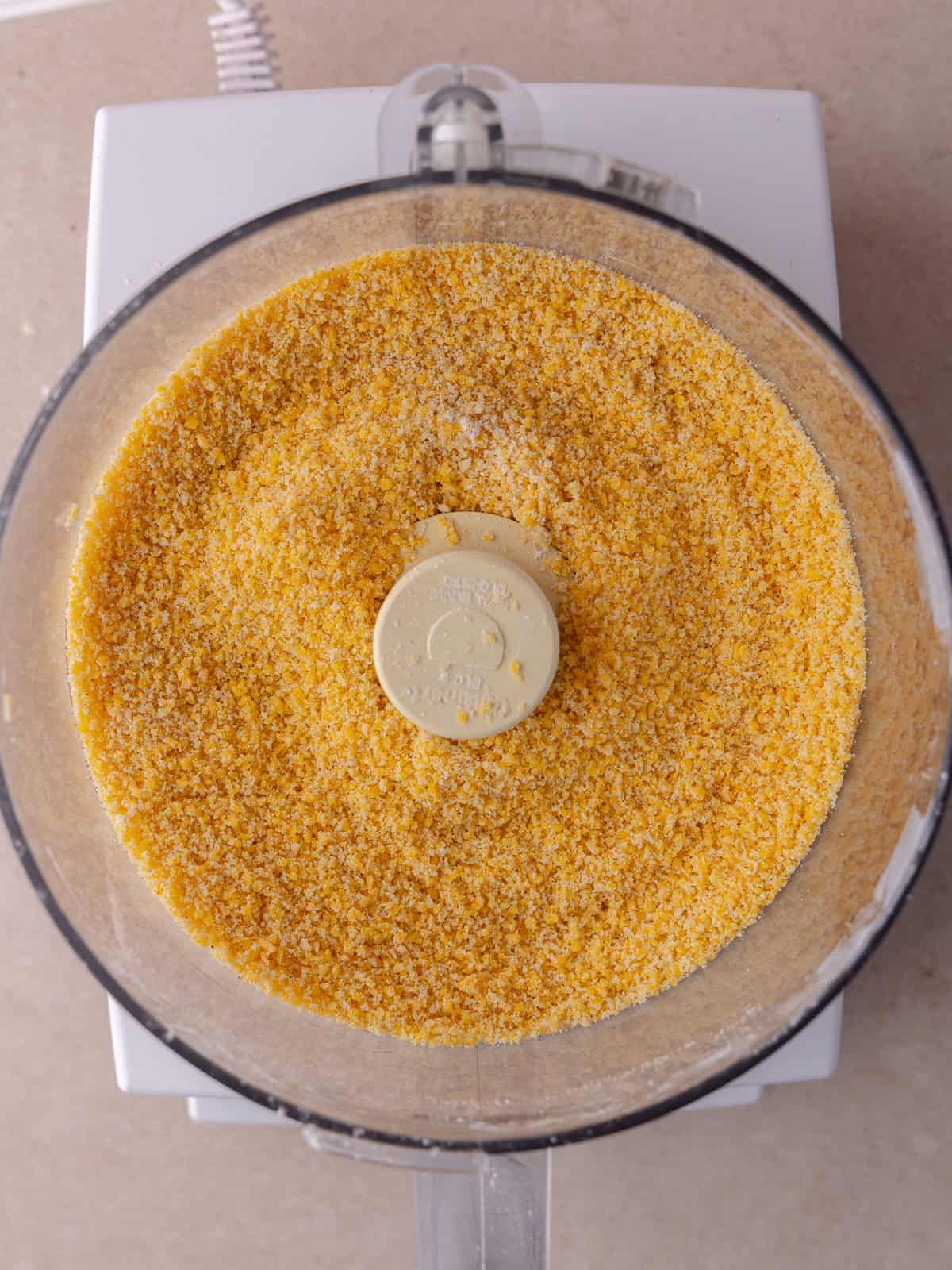 All purpose flour, cornstarch, cheddar cheese, butter and paprika are in the bowl of a food processor are pulsed until the mixture is fine.