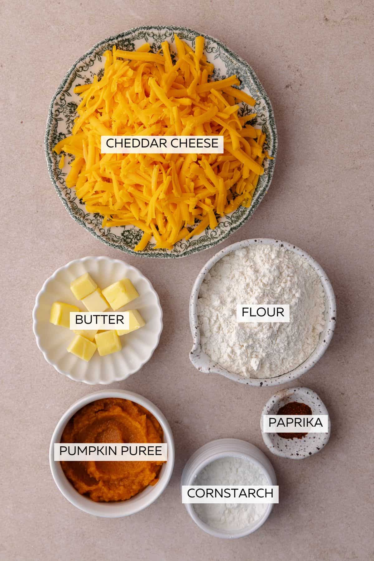 Ingredients of Pumpkin Cheddar Crackers which include, all purpose flour, cornstarch, shredded cheddar cheese, butter cubes, pumpkin puree and paprika.