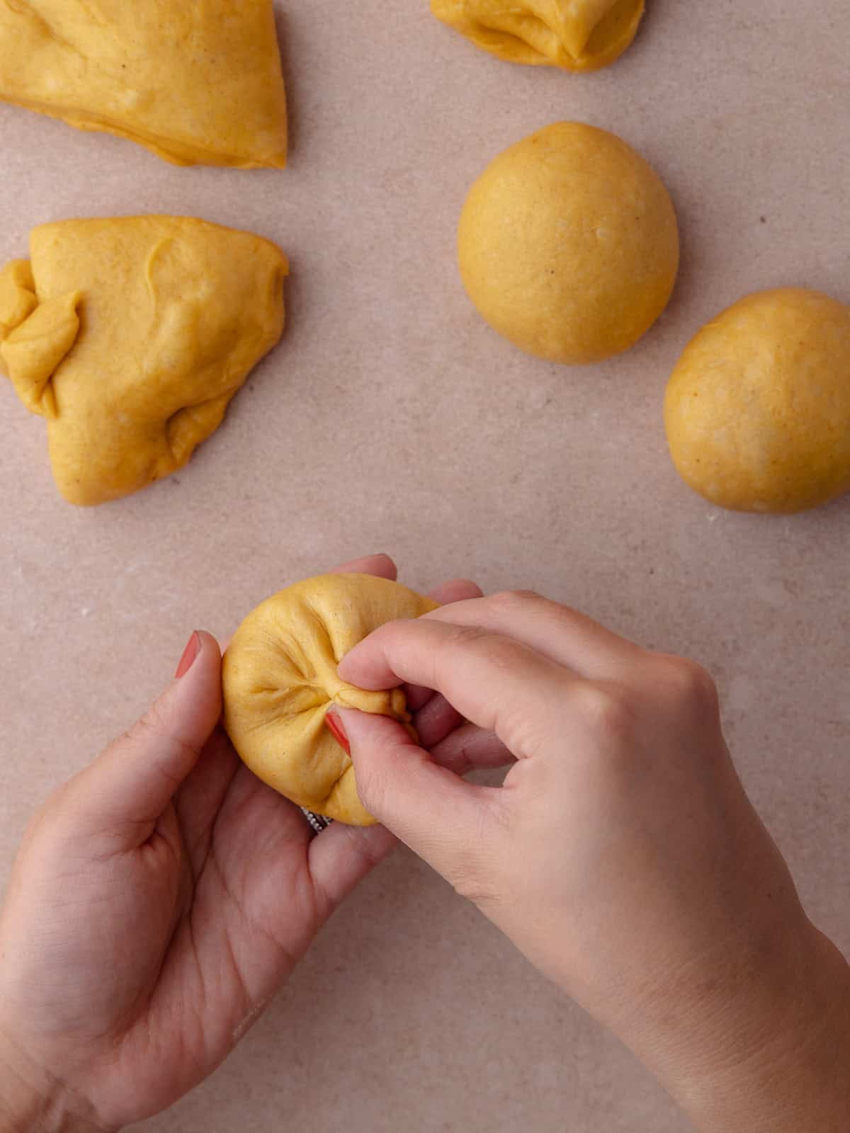 The edges of the dough is gathered together to form a rough ball of dough.