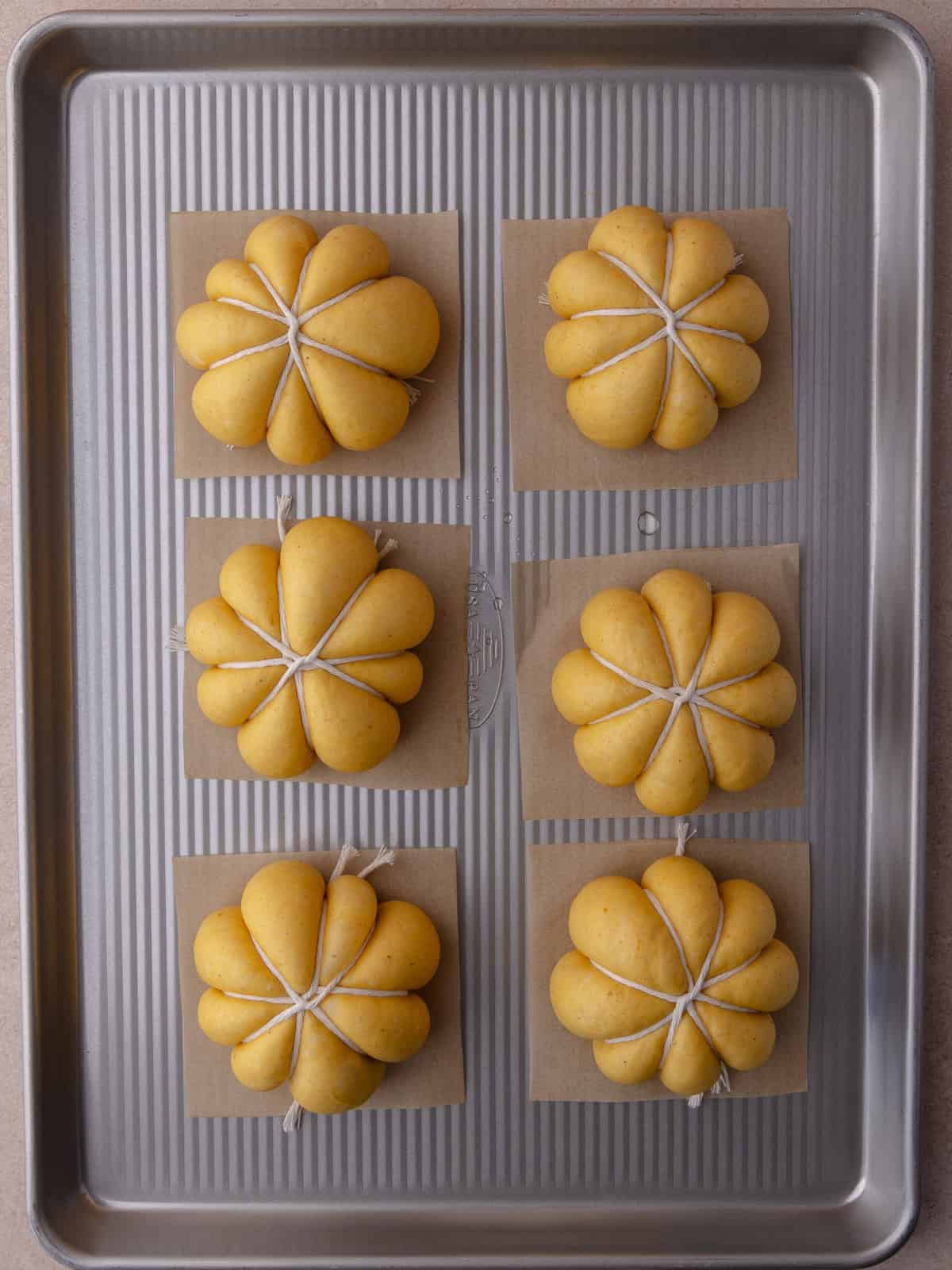 Pumpkin donuts have finished proofing and is now ready for frying. The donuts have puffed and nearly doubled in size.