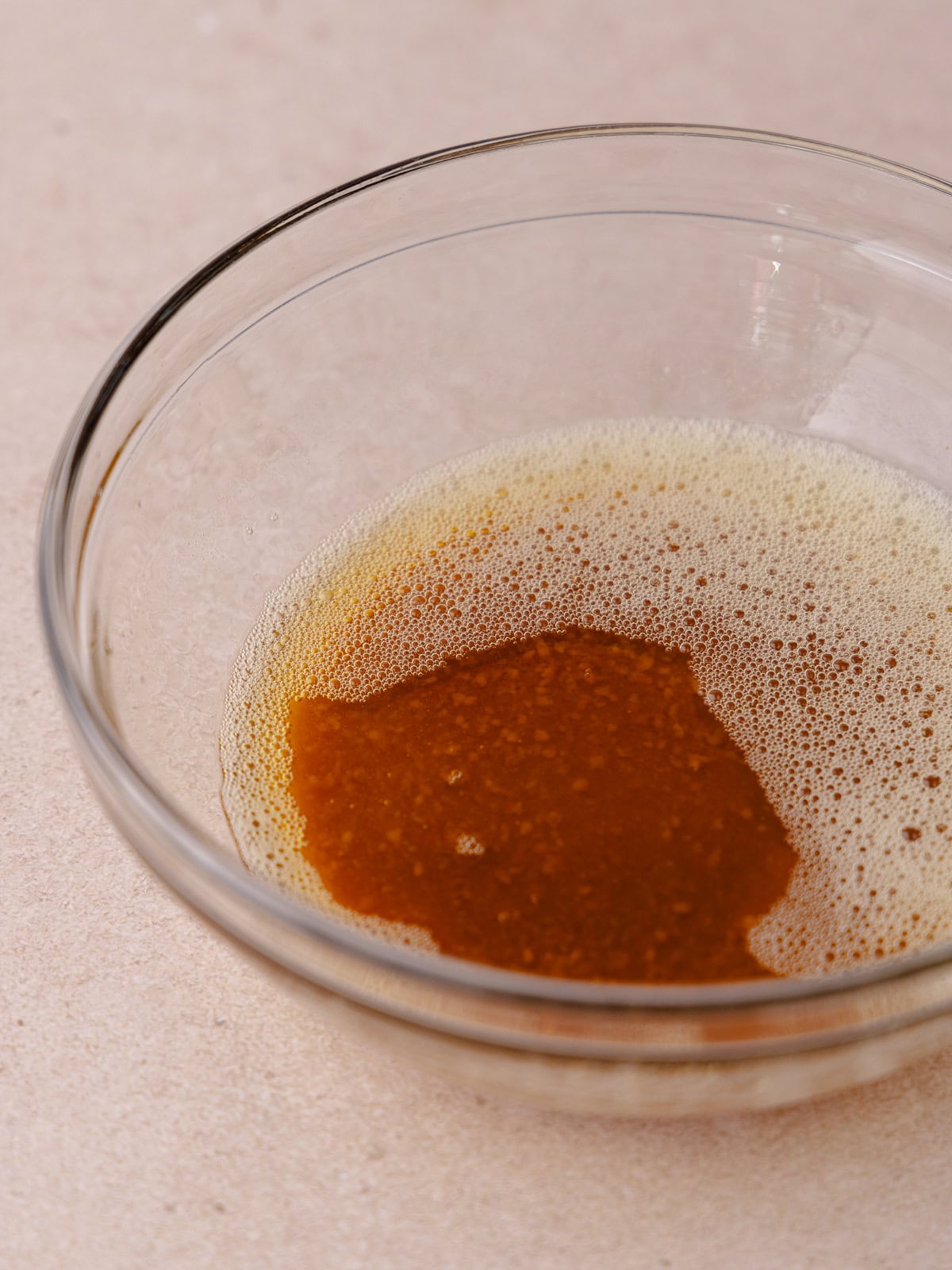 Brown butter and toasted milk powder are sitting in a small glass bowl.