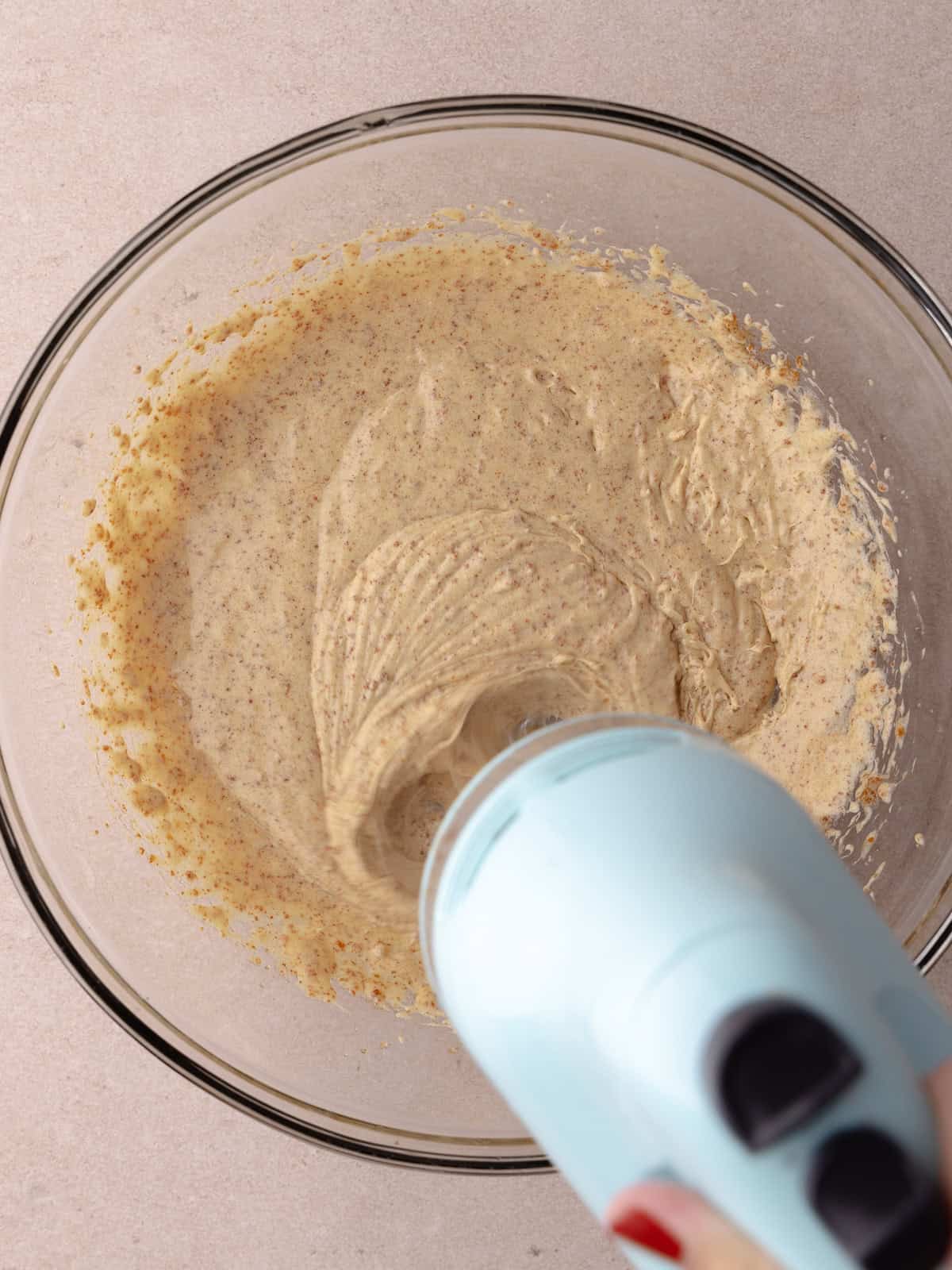 Hand held mixer is mixing the egg into the butter/sugar mixture.