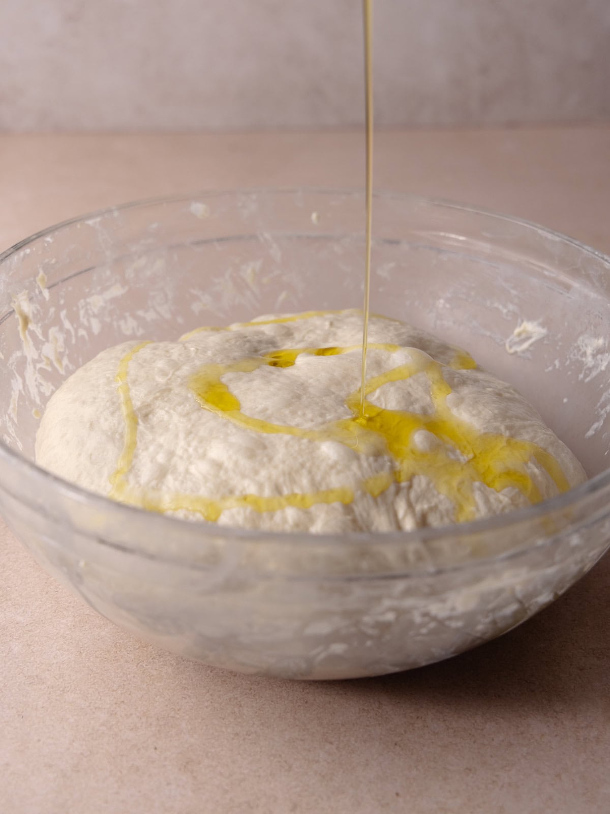 Extra-olive virgin olive oil is poured on top of the dough.