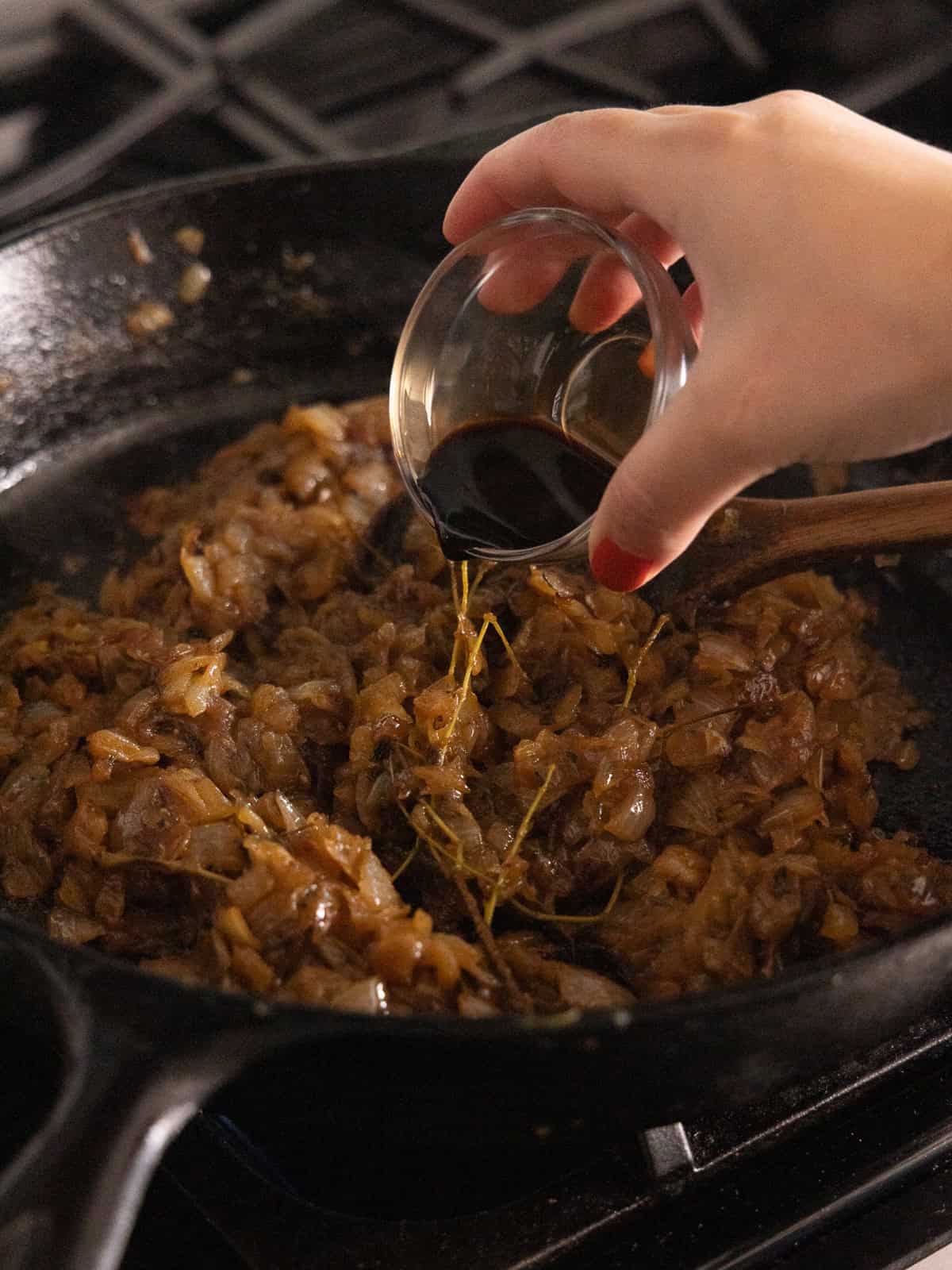 Diced onions, thyme, salt and pepper are cooked in a large cast iron pan.