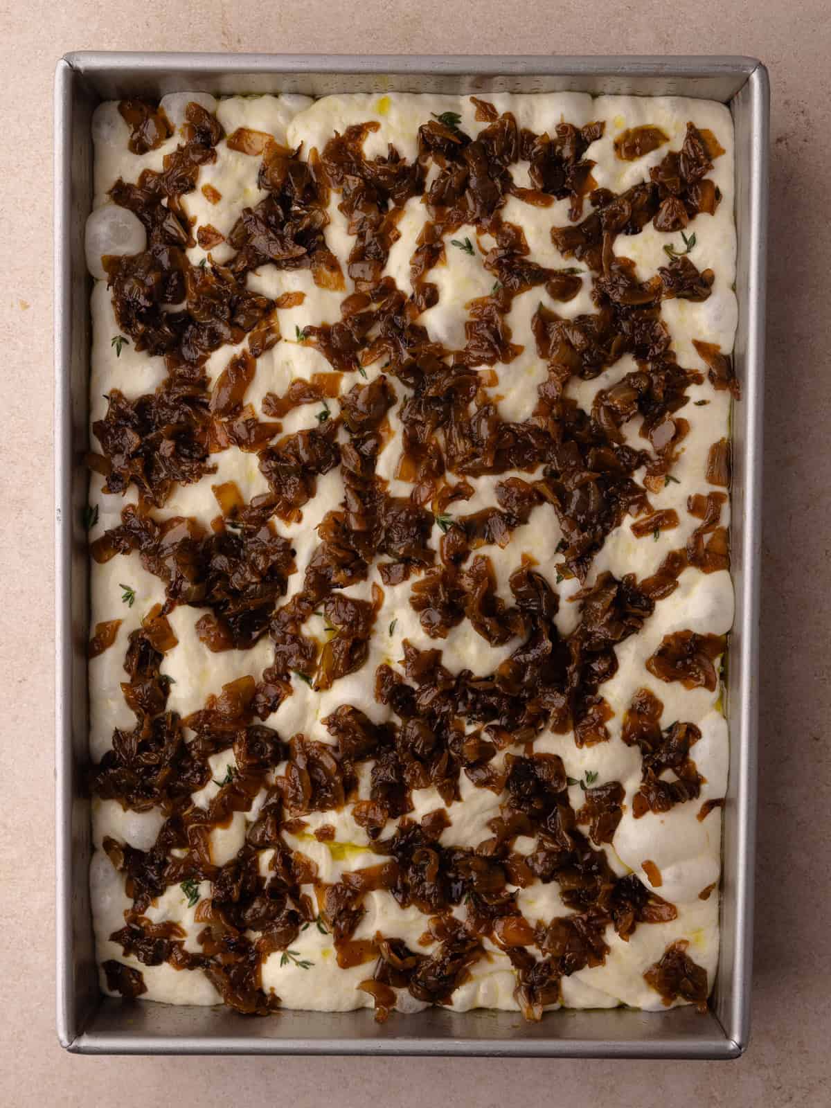 Caramelized onions are added on top of the focaccia.