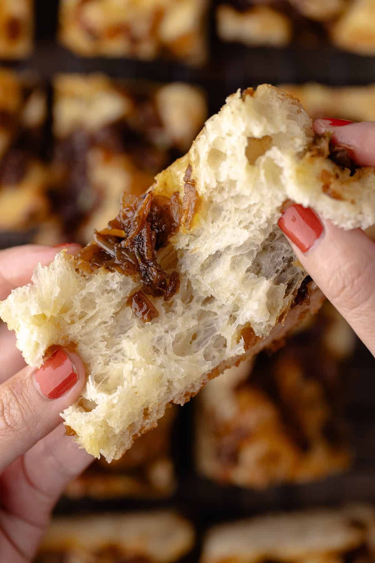 A close up of the inside of a piece of overnight caramelized onion focaccia.