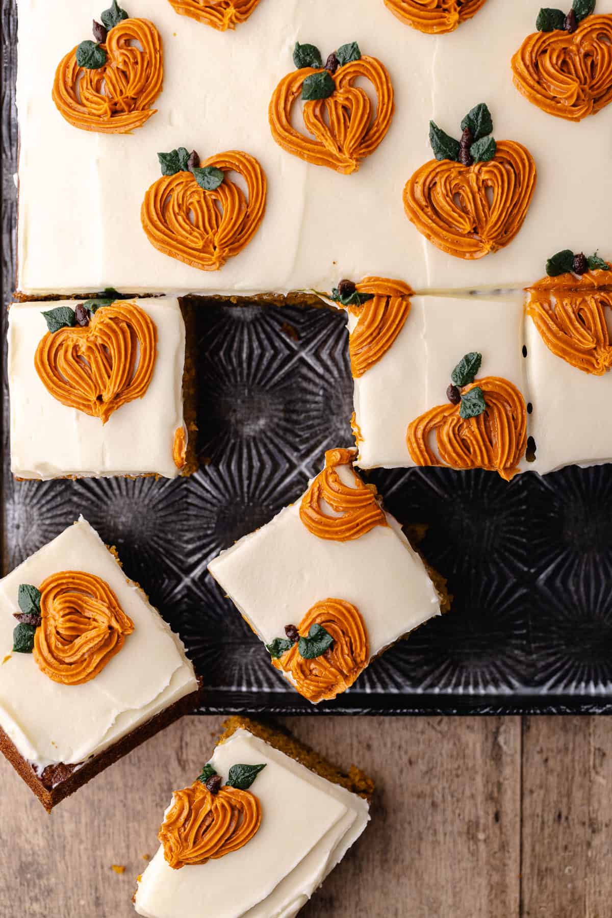 Pumpkin chai cake are cut into small squares on a baking sheet.