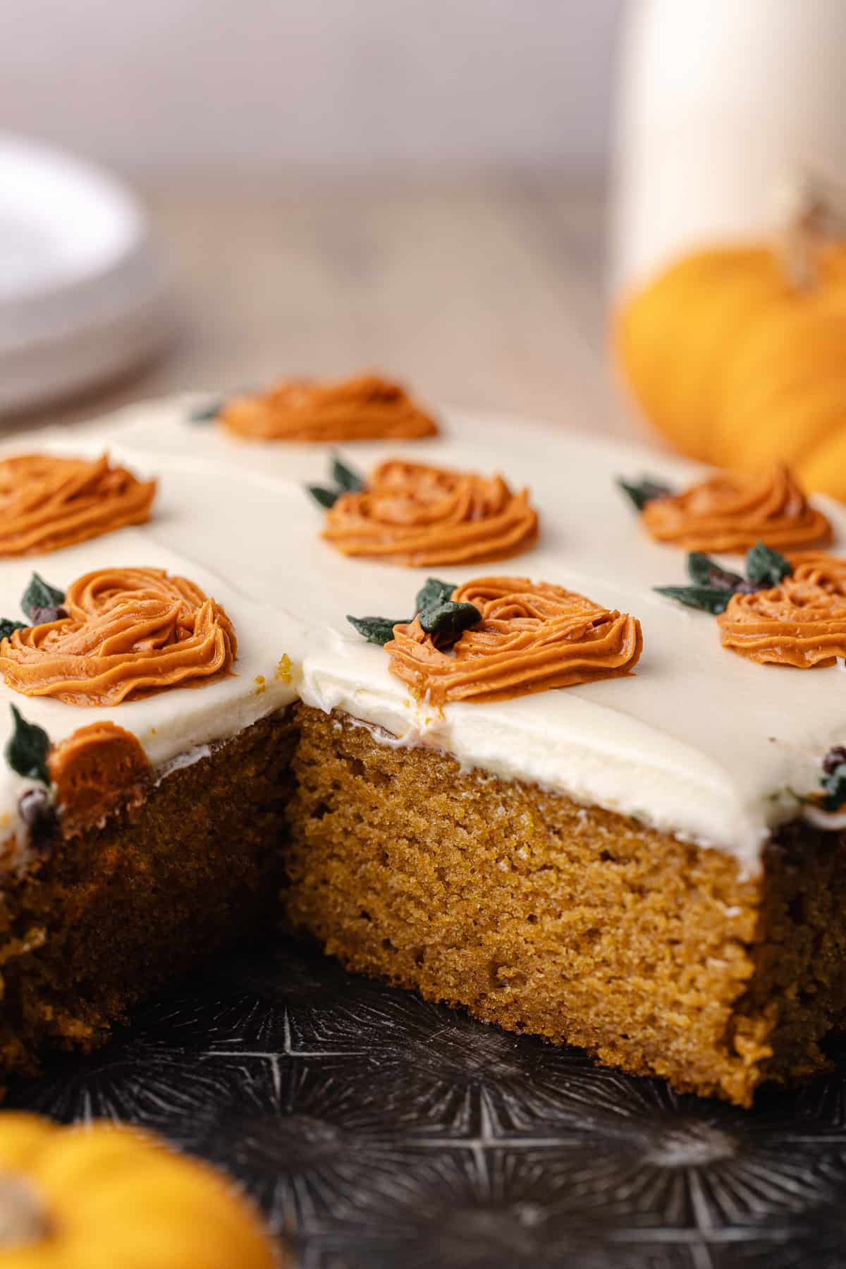 Pumpkin Chai Cake on a baking sheet. Dessert plates, a bottle of milk and pumpkins are around.