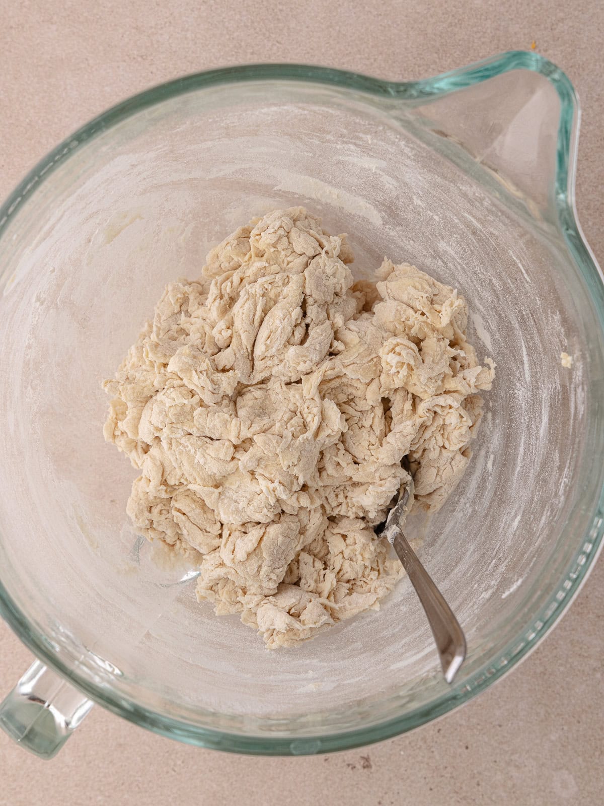 A shaggy dough sits in a large glass bowl.