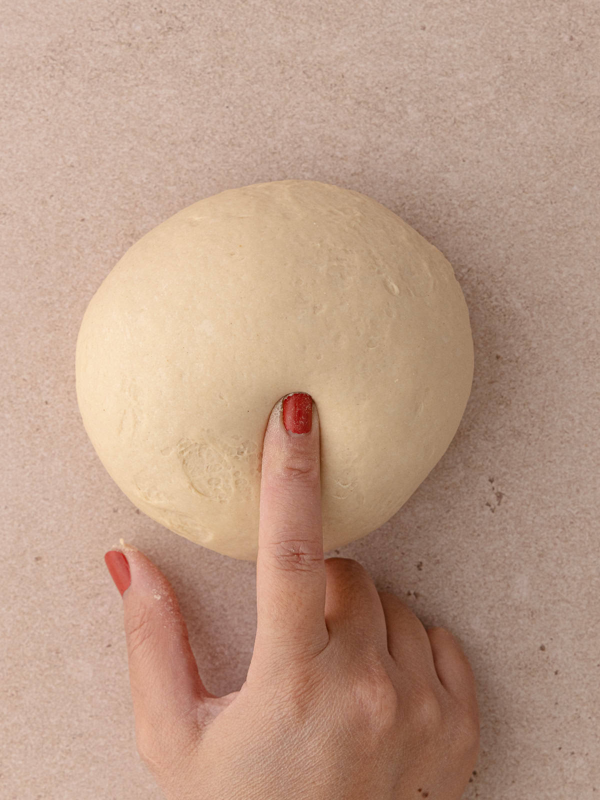 A finger presses into the kneaded dough.