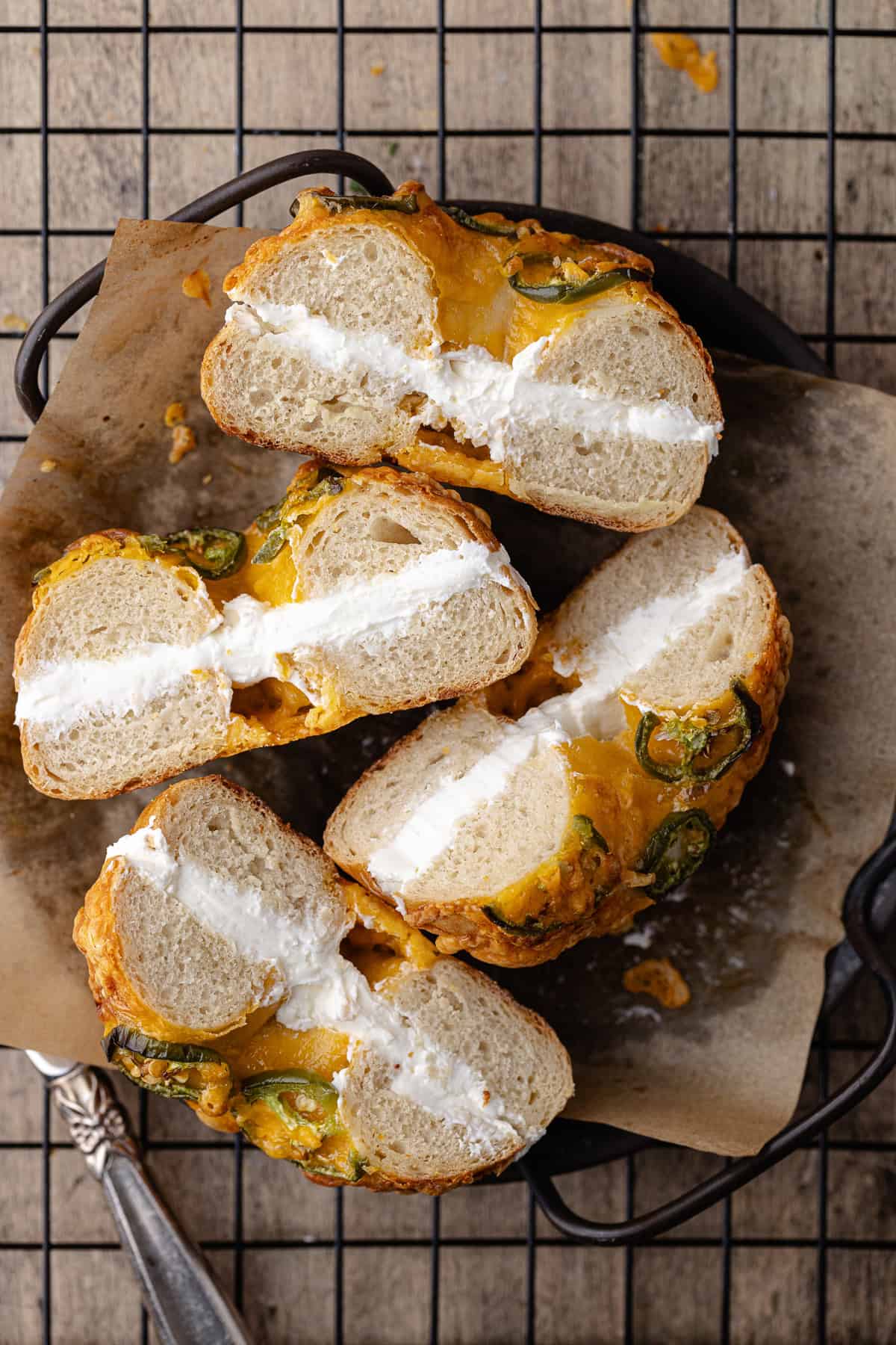 Jalapeño cheddar bagels filled with cream cheese schmear on a plate.