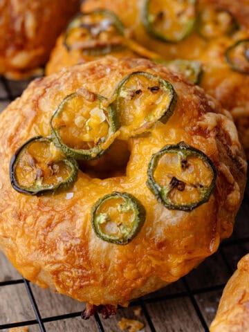 Jalapeno cheddar bagels on a wire rack featured photo.