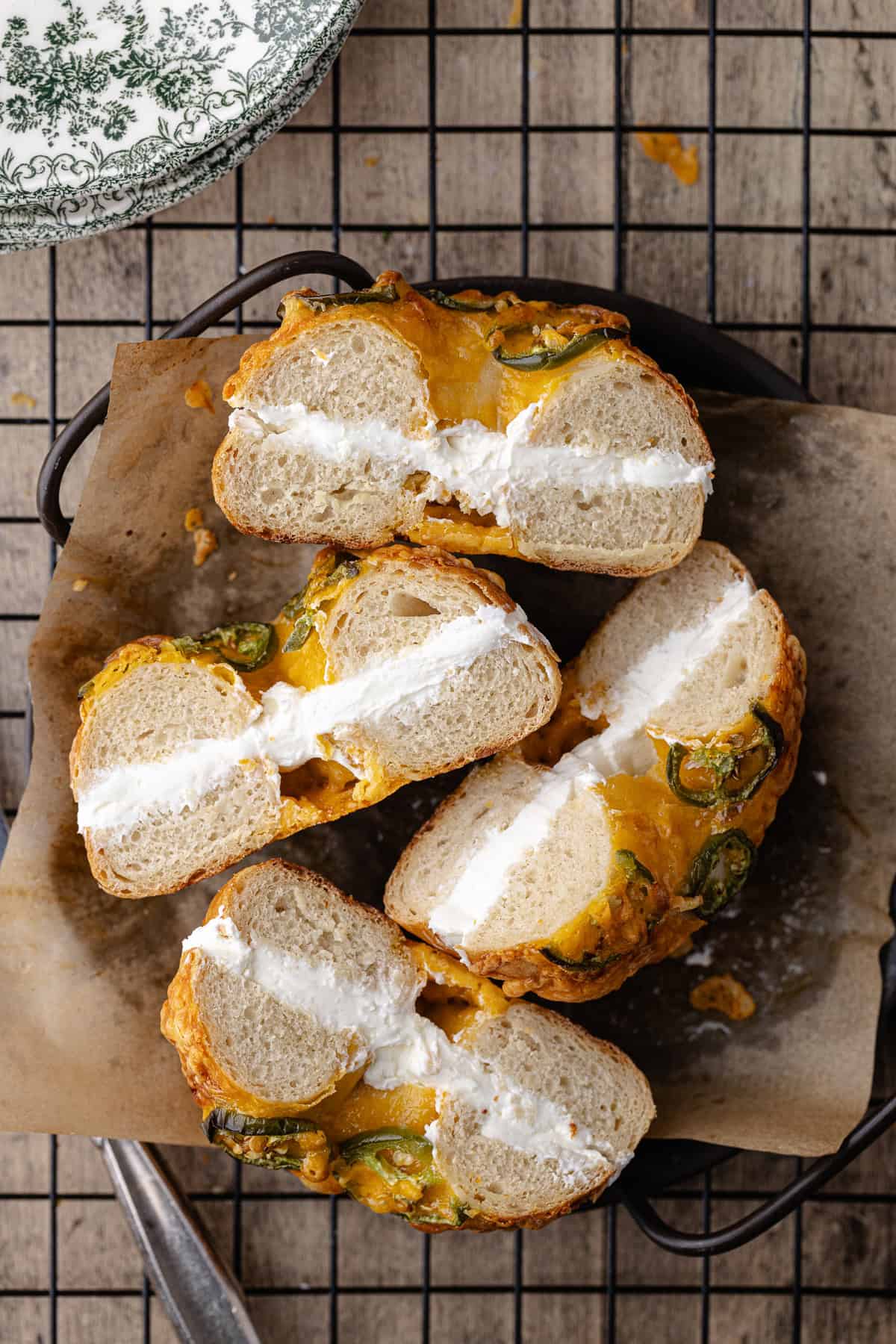 Jalapeño cheddar bagels filled with cream cheese schmear sitting on a plate.