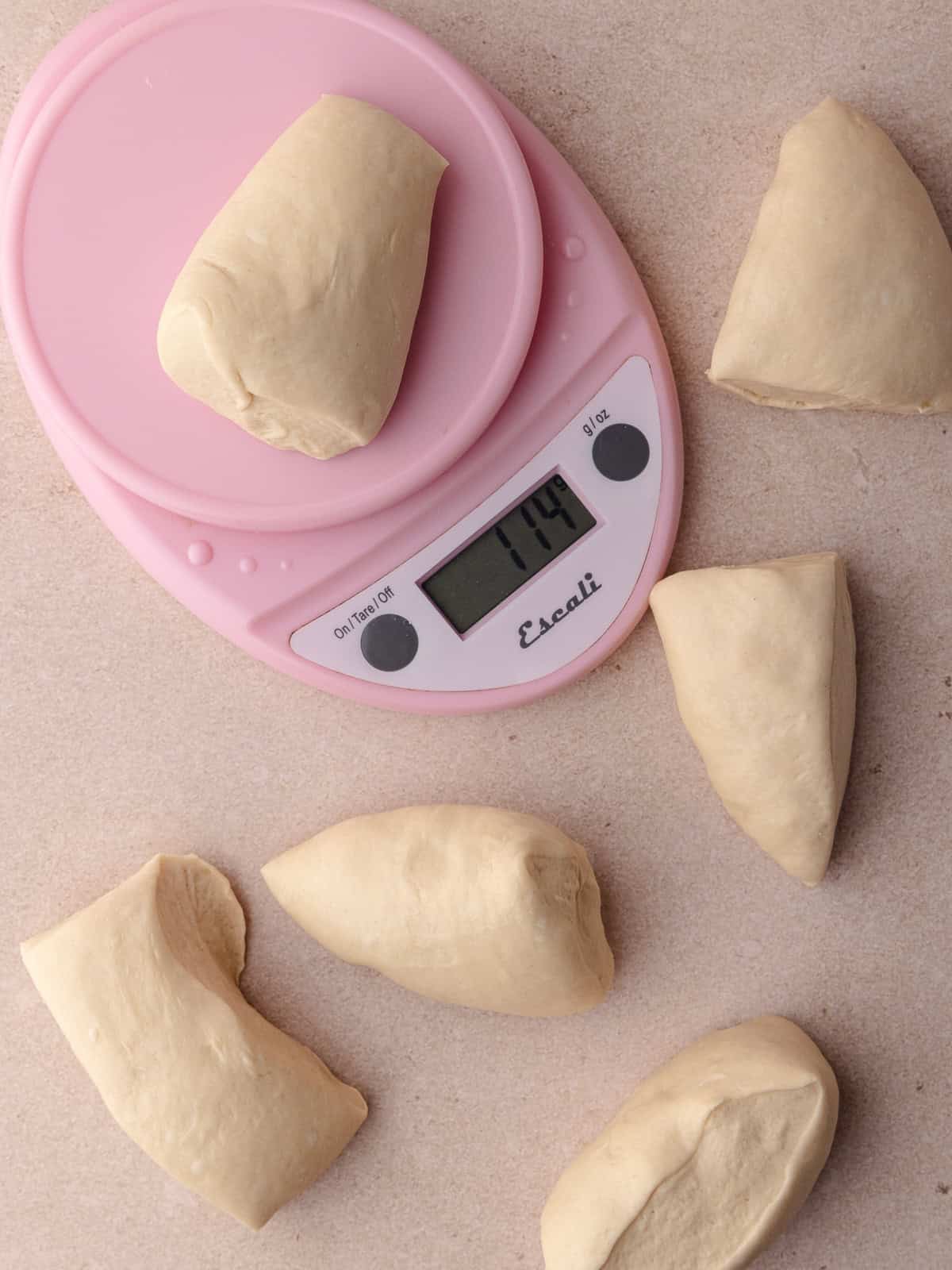 The bagel dough is divided into 6 equal pieces with the help of a kitchen scale.