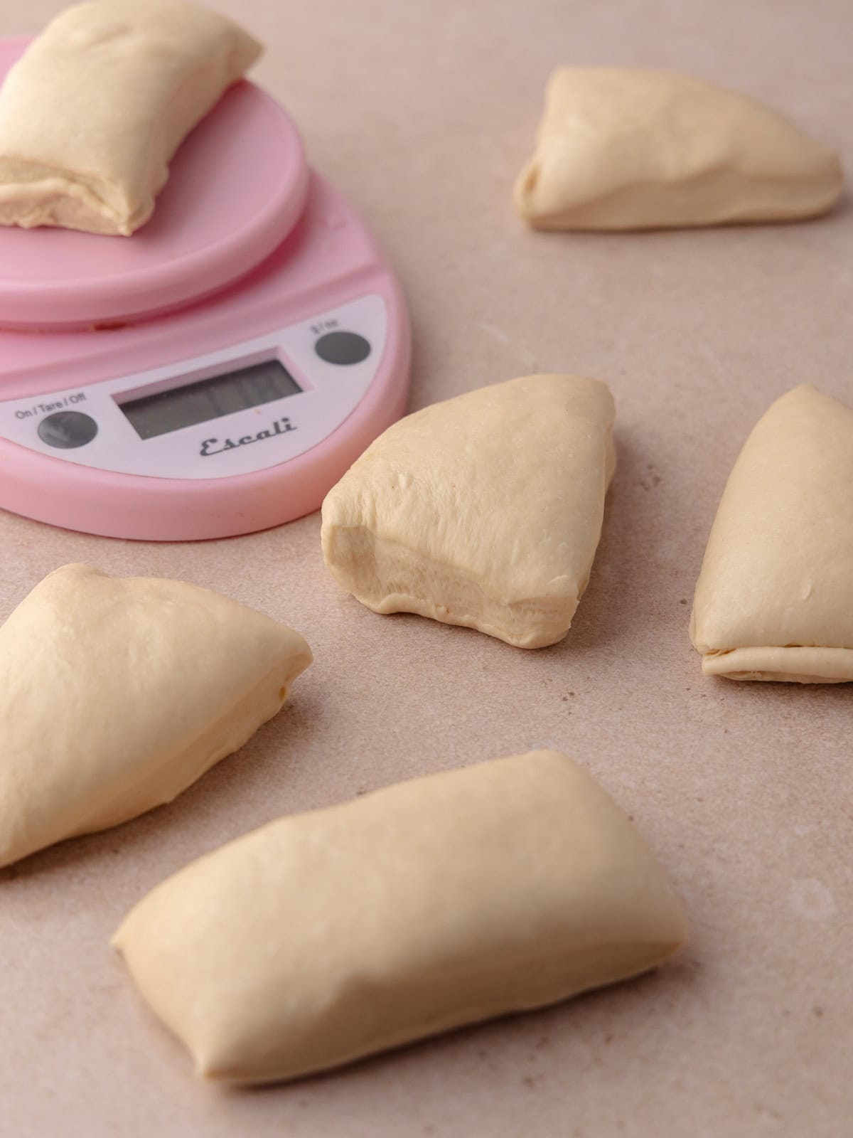 Dough is divided into 6 equal pieces using a kitchen scale.