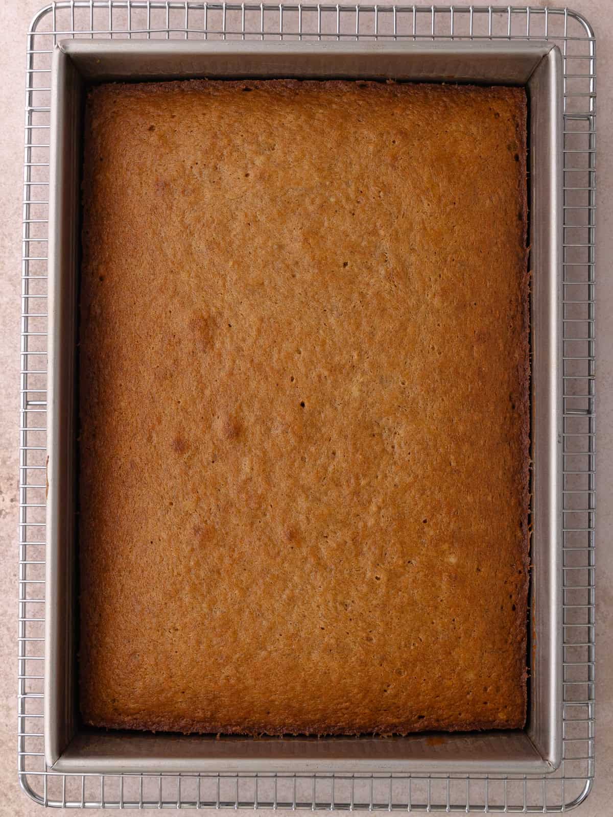 Spiced banana cake is baked until golden brown and sitting on a cooling rack.