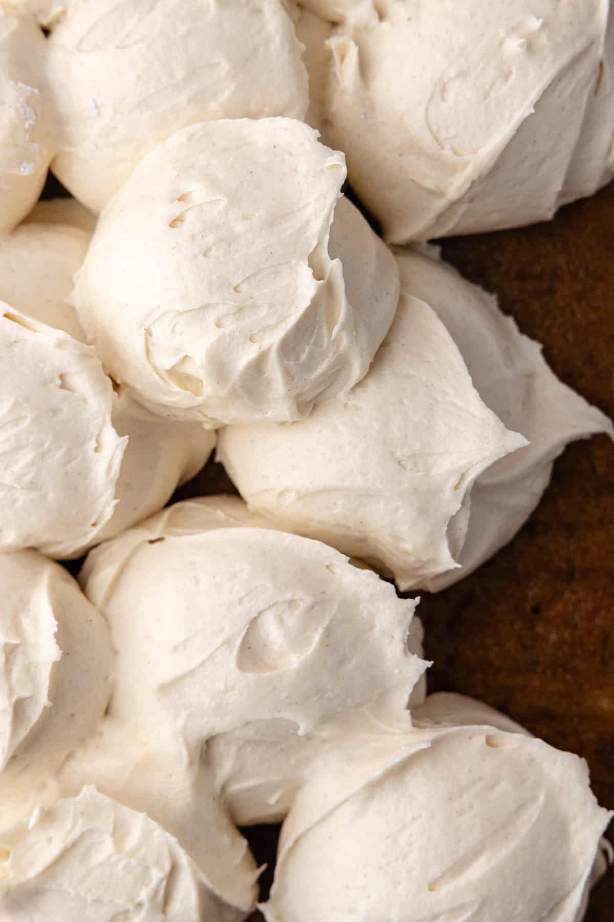 Scoops of maple cream cheese frosting is on top of the spiced banana cake.