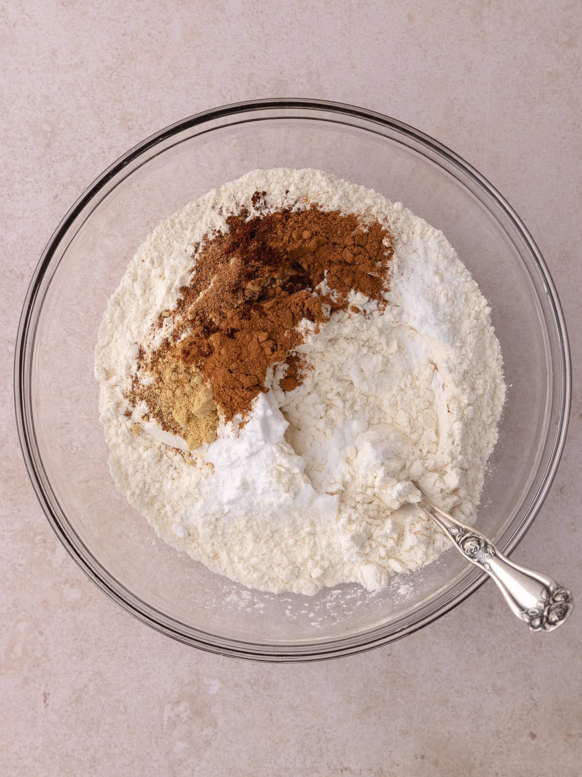 Spiced banana cake dry ingredients are combined in a glass mixing bowl.