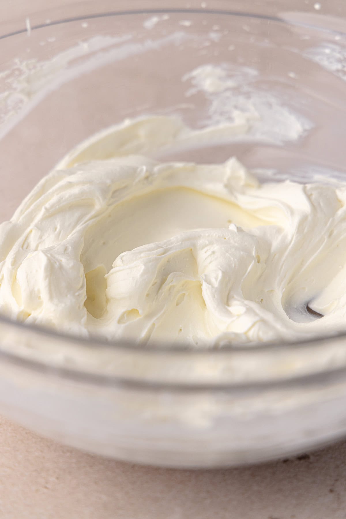 Close up of the bagel schmear which is a spreadable cream cheese, sitting in a medium glass bowl.