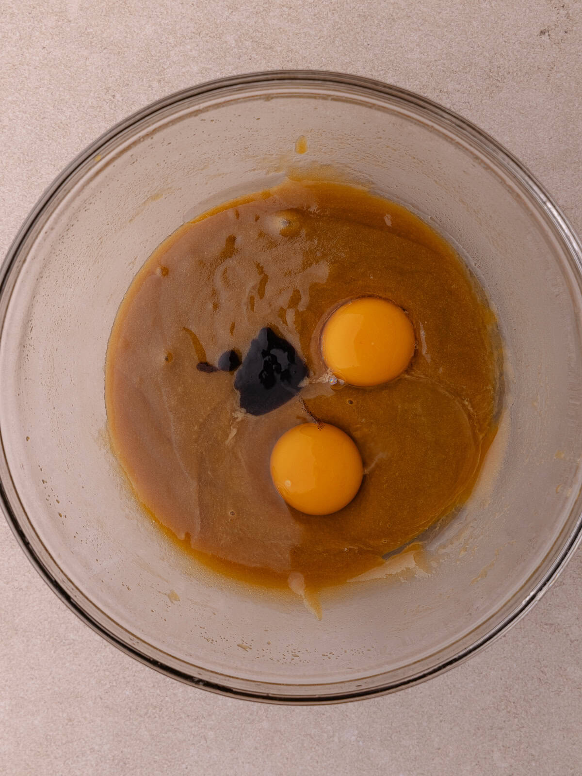 One whole egg, one yolk and vanilla are added into the bowl with the butter/sugar mixture.