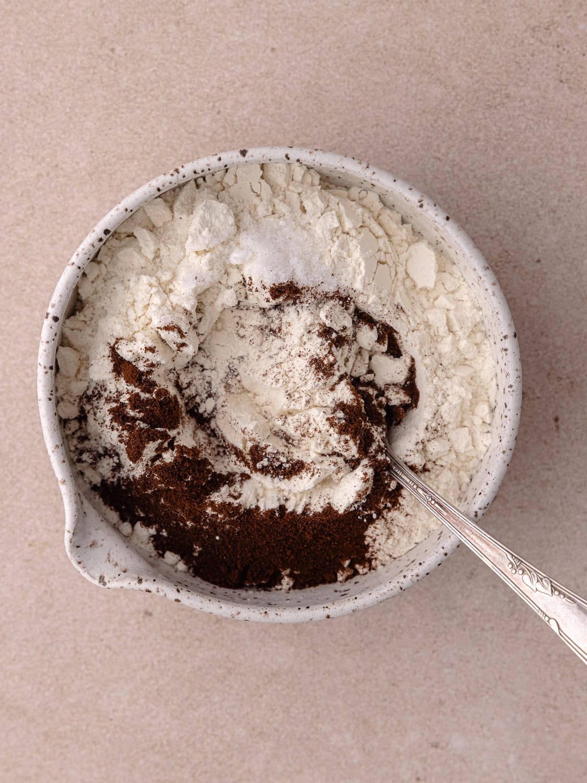 All-purpose flour, espresso powder and salt are in a small mixing bowl with a spoon.