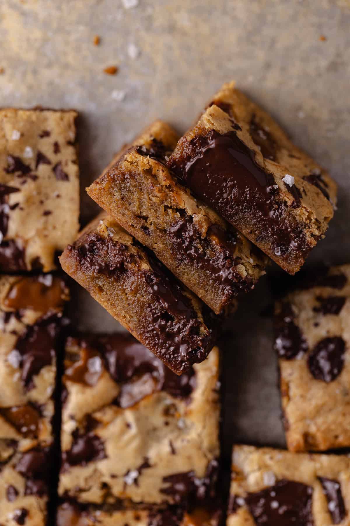 A close up of toffee espresso blondies cut in squares are sitting on a baking sheet.