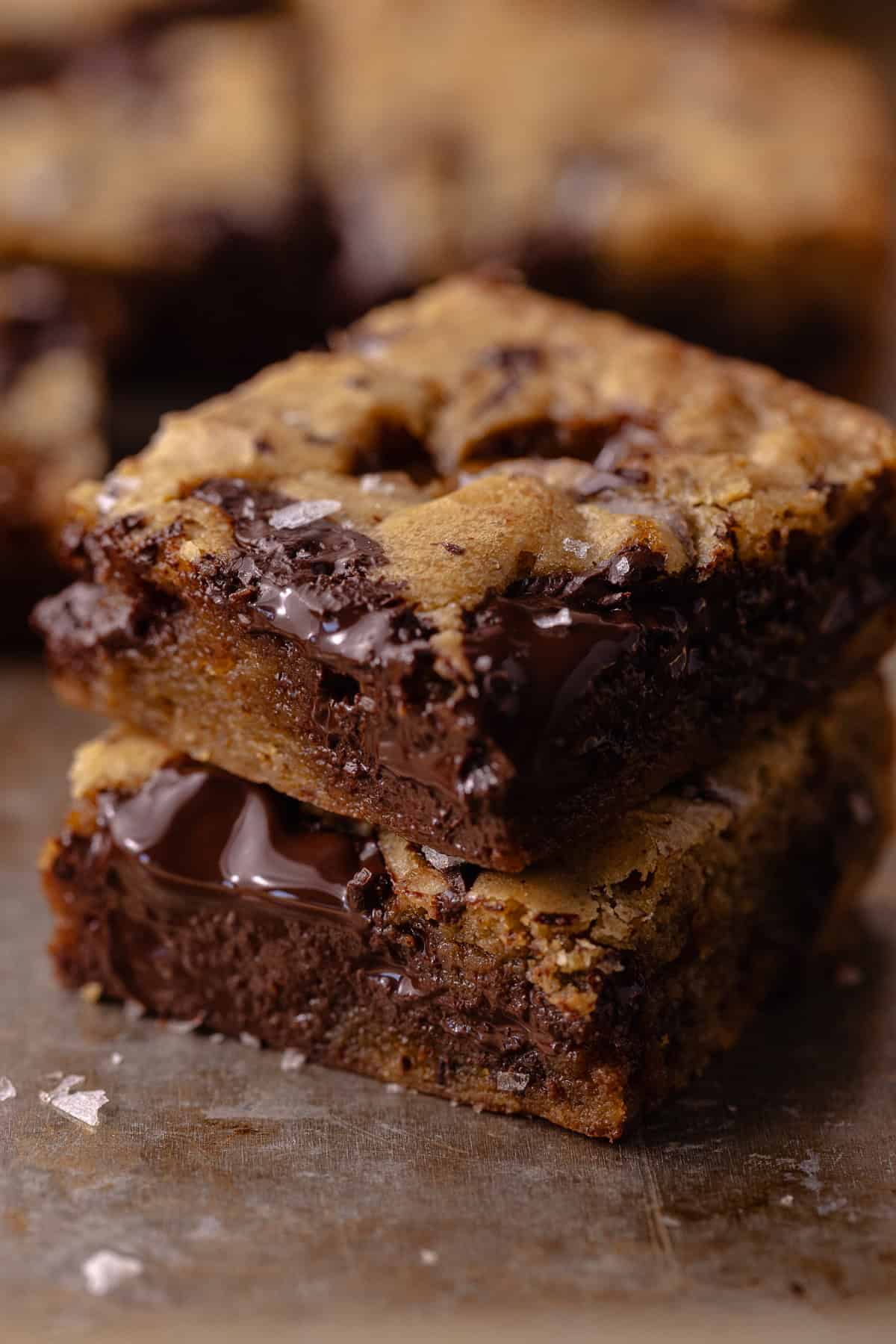 A close up a stack of salted toffee espresso blondie square sitting on a baking sheet.