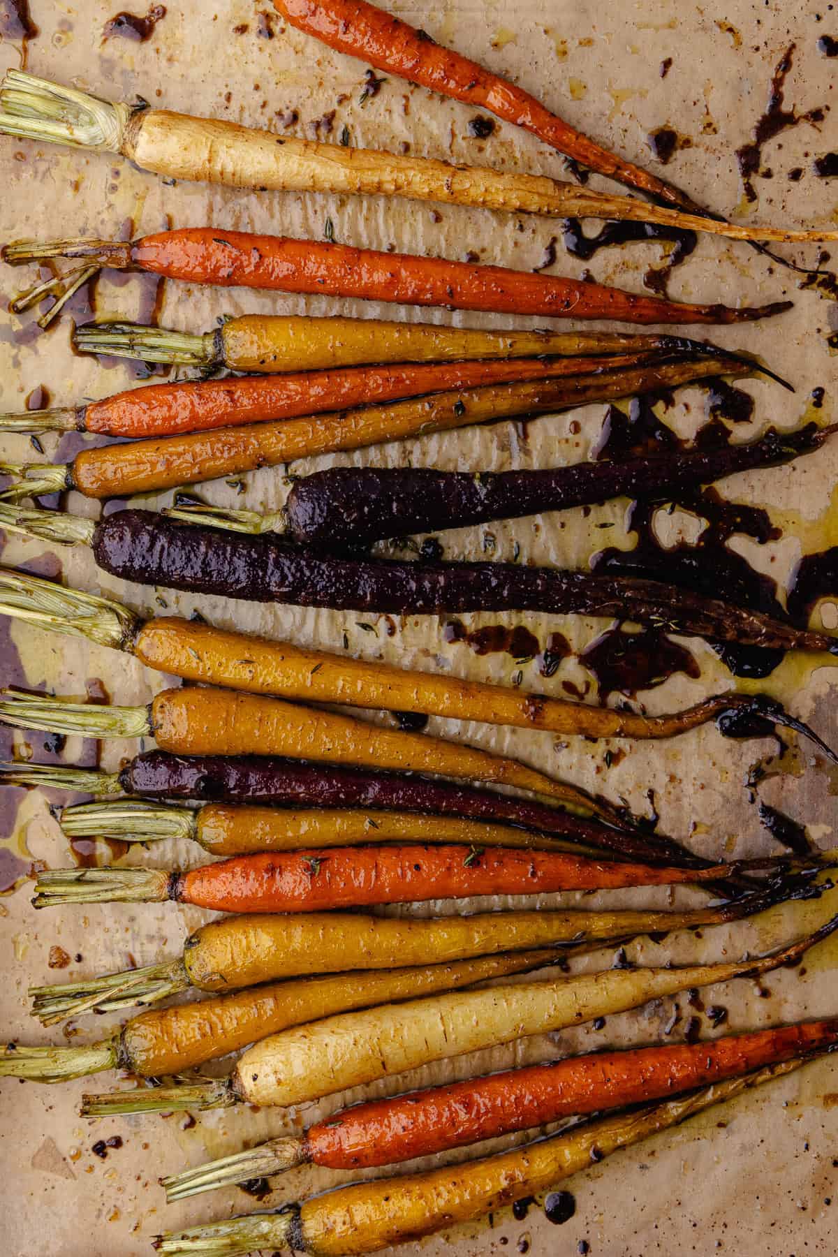 Roasted carrots and sitting on a baking sheet lined with parchment paper.