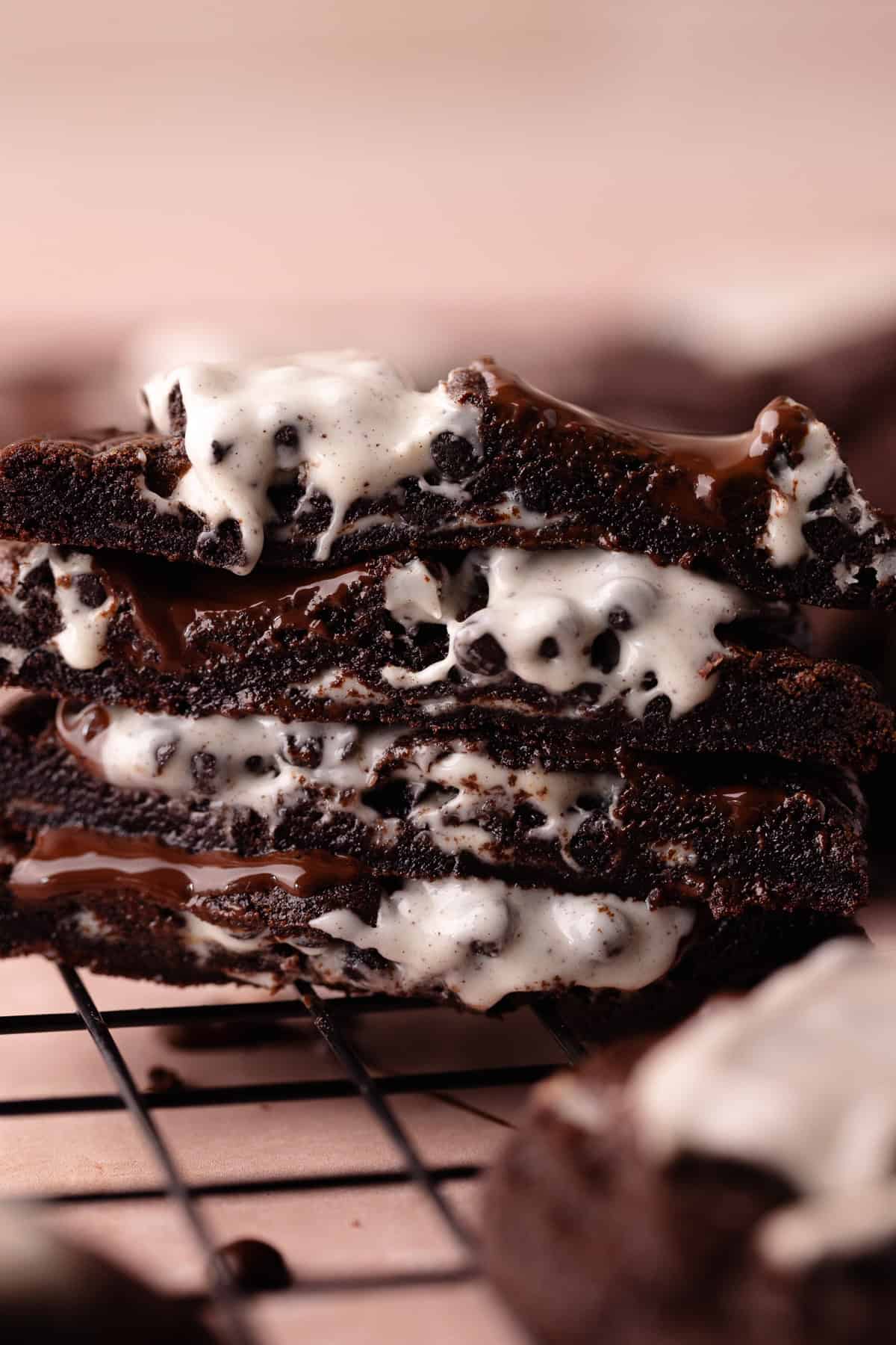 Close up of a cross section of gooey and warm Chocolate cookies and cream cookies sitting on a wire rack.