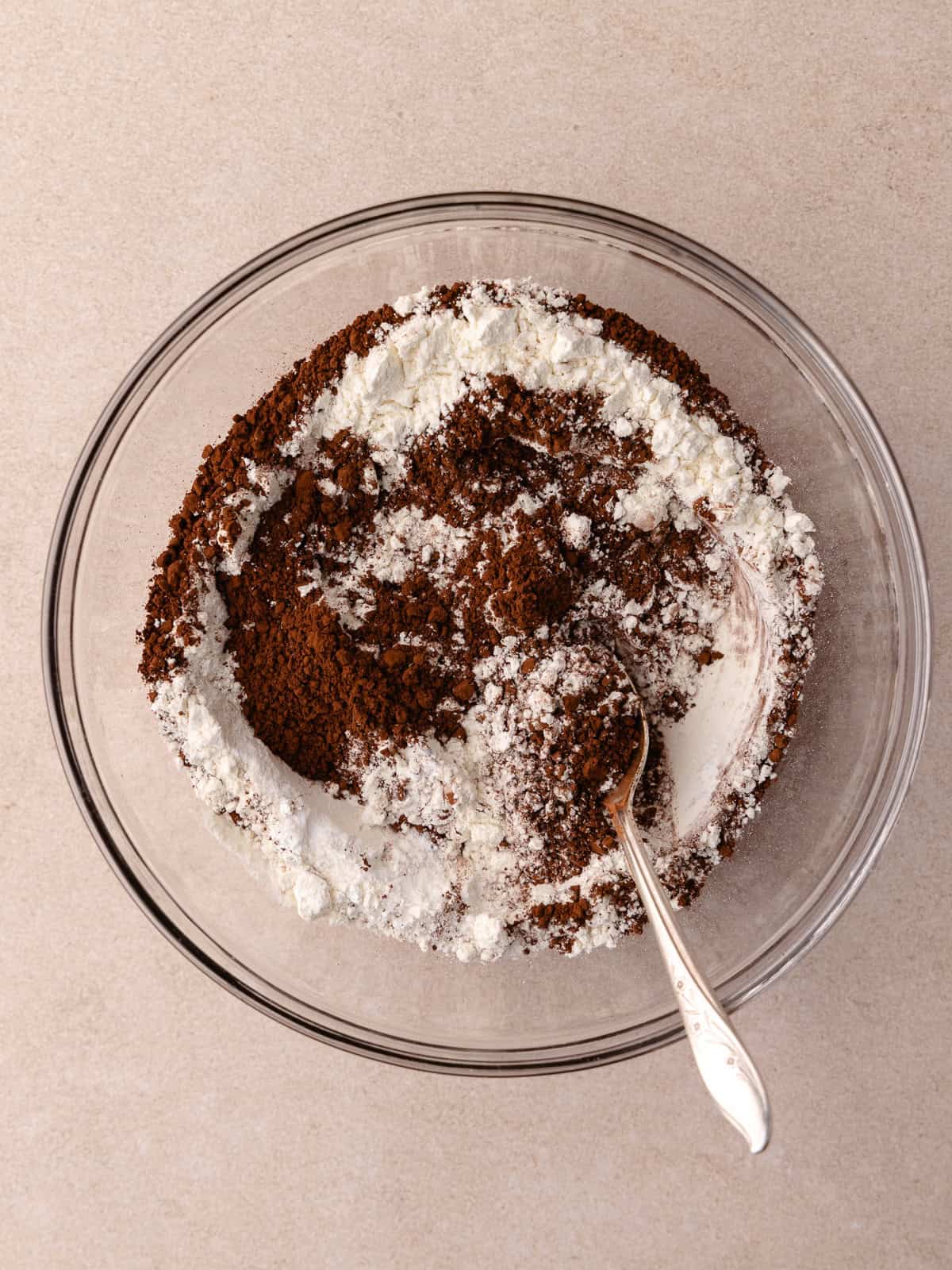 All-purpose flour, cocoa powder, baking soda, baking powder and salt are combined together in a medium glass bowl.