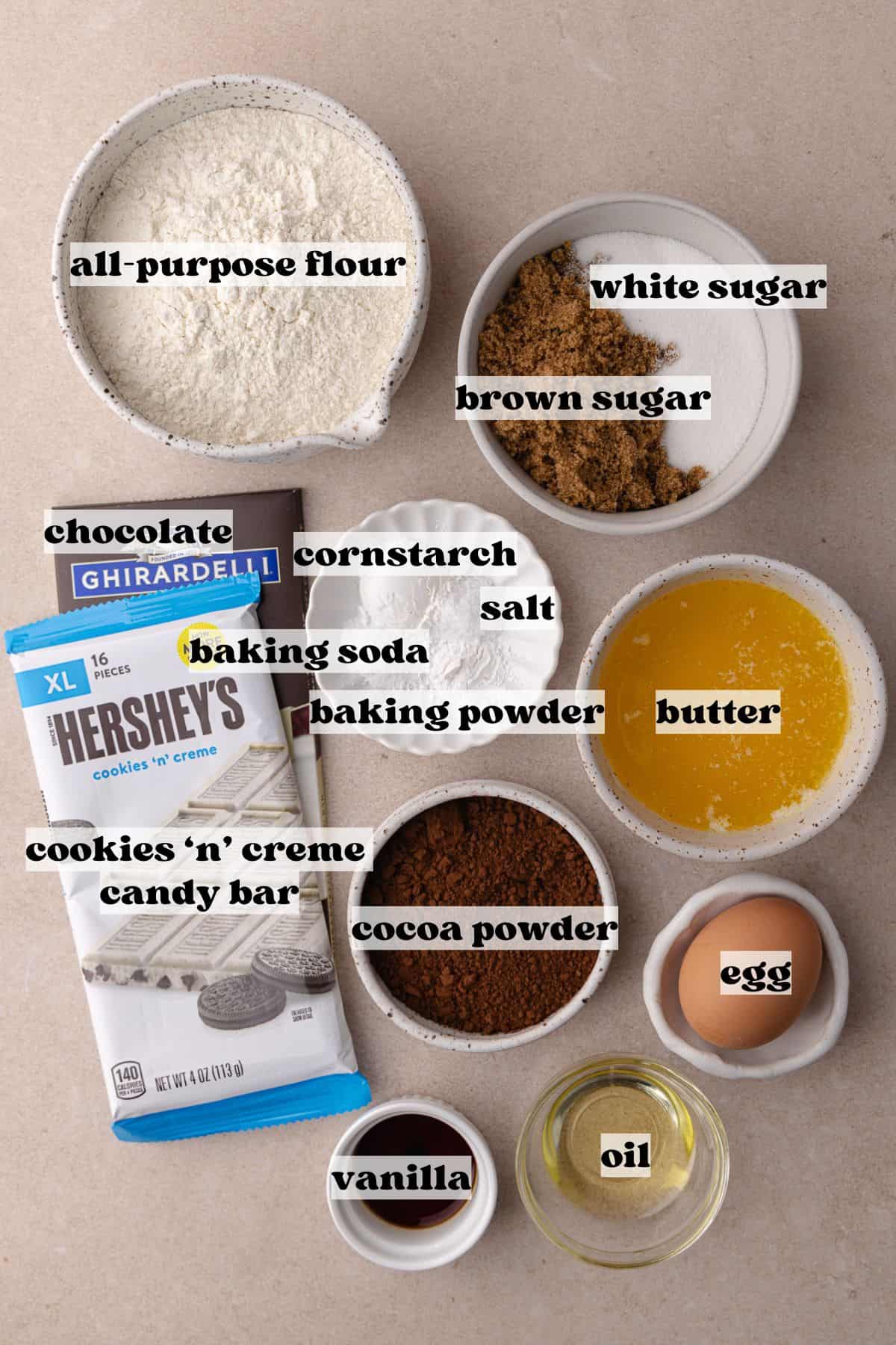 Chocolate cookies and cream cookies ingredients which include, all-purpose flour, cocoa powder, baking soda, baking powder, salt, cornstarch, brown sugar, white sugar, egg, butter, oil, cookies n' creme candy bar and chocolate bar.