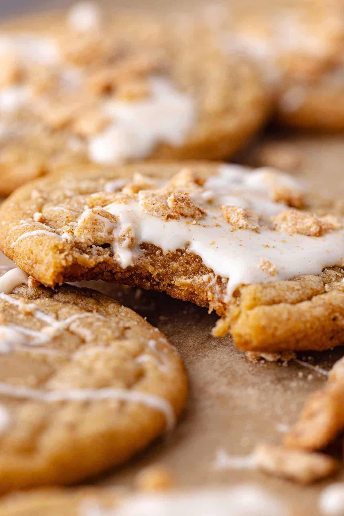 A close up of the inside of a soft and chewy cinnamon toast crunch cookie drizzled with white chocolate and crushed cinnamon toast crunch cereal.