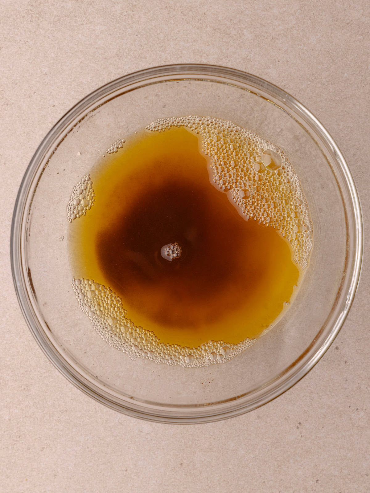 Brown butter is poured into a small glass bowl.